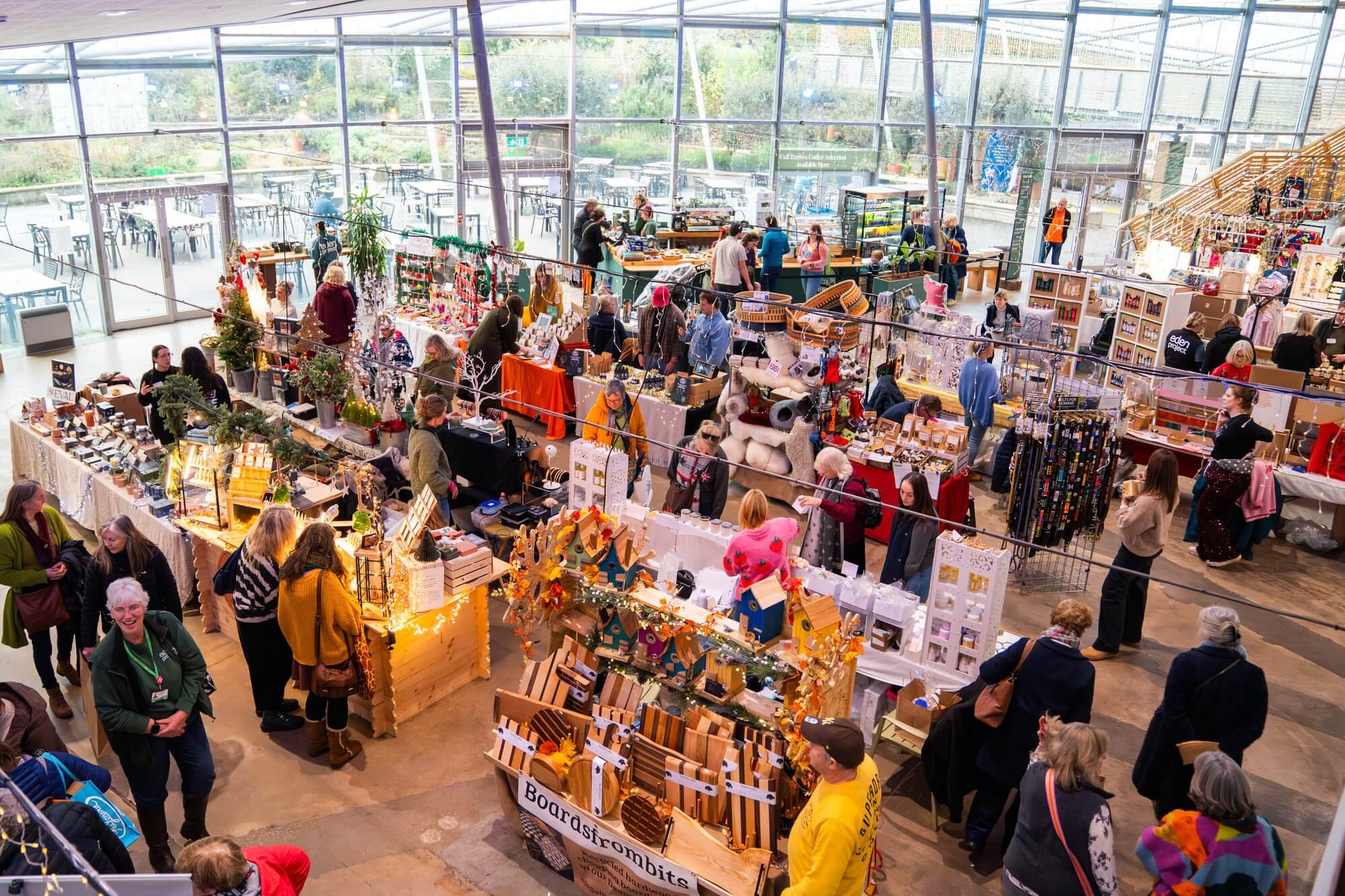 Shoppers browsing stalls at the Cornwall Christmas Fair inside the Eden Project's Mediterranean Biome