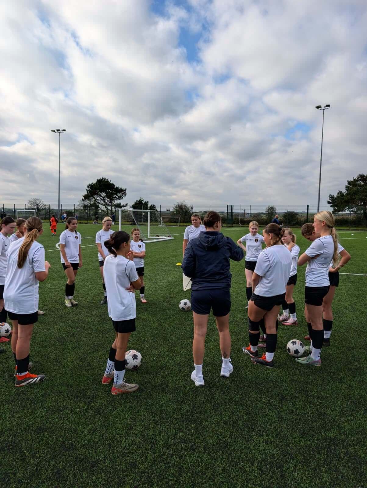 A girls' football team gathered round their coach for a team talk