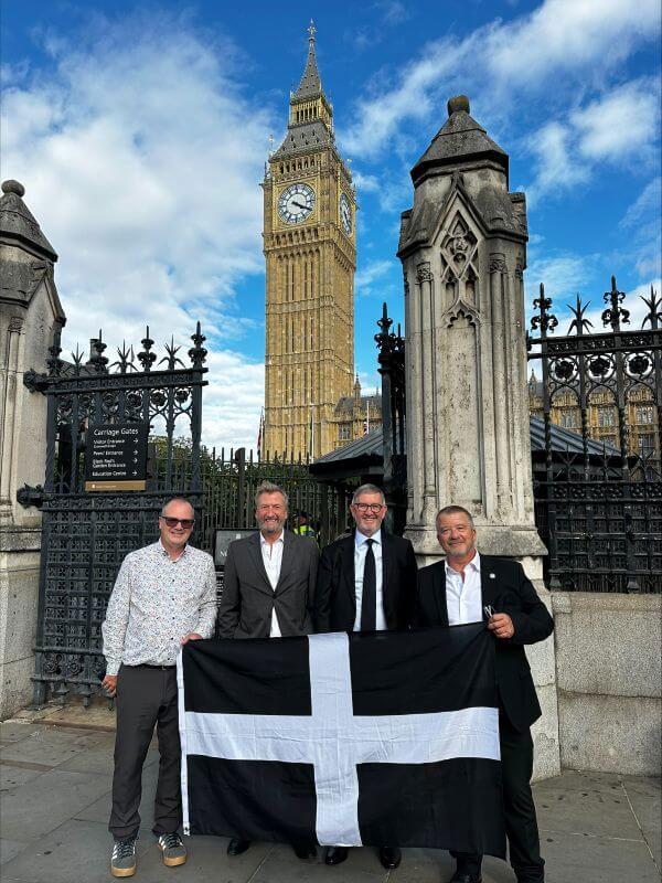 Cornwall representatives holding the Cornish flag outside the Houses of Parliament