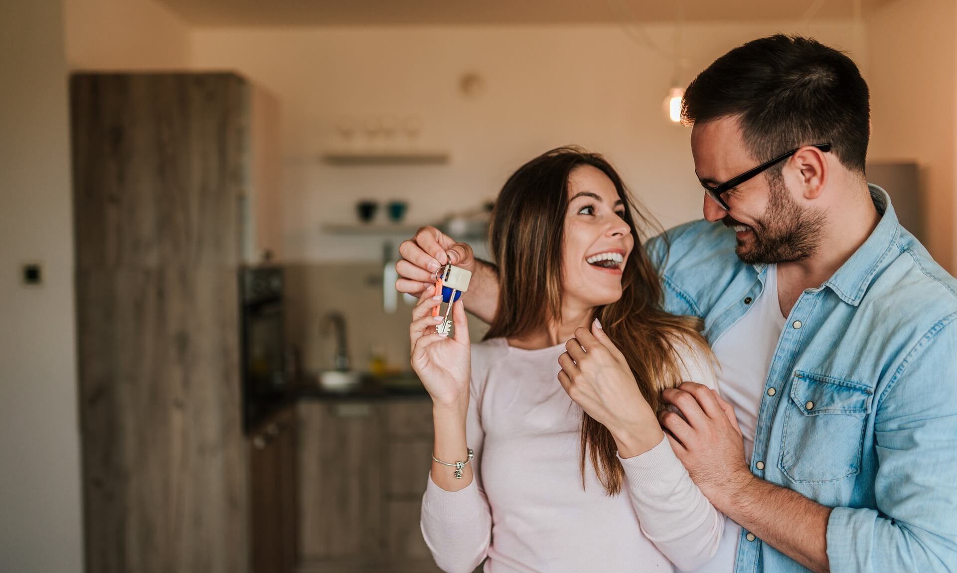 Couple celebrating with house keys in a Cornwall home