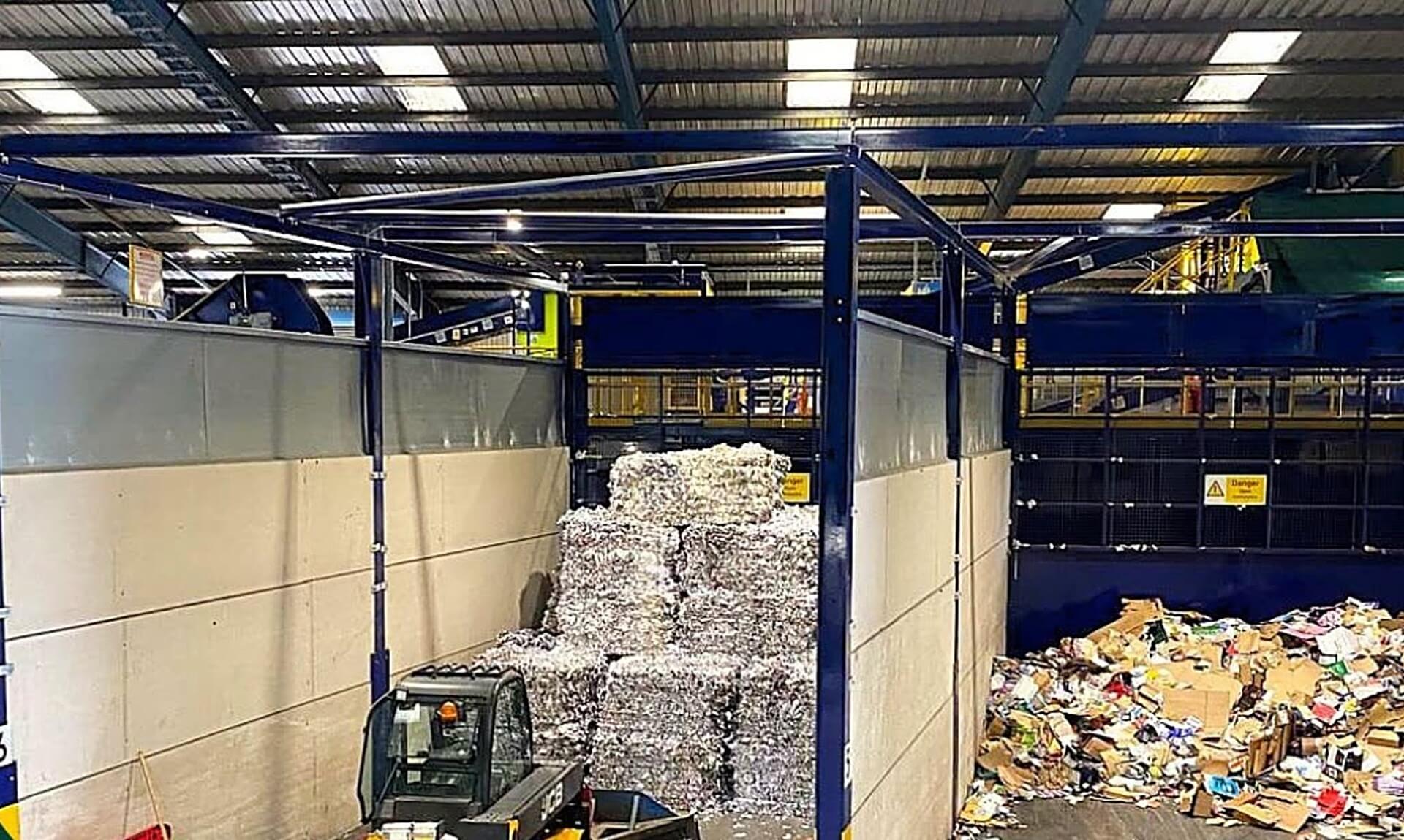 Forklift loader moving baled paper at a Cornwall recycling facility