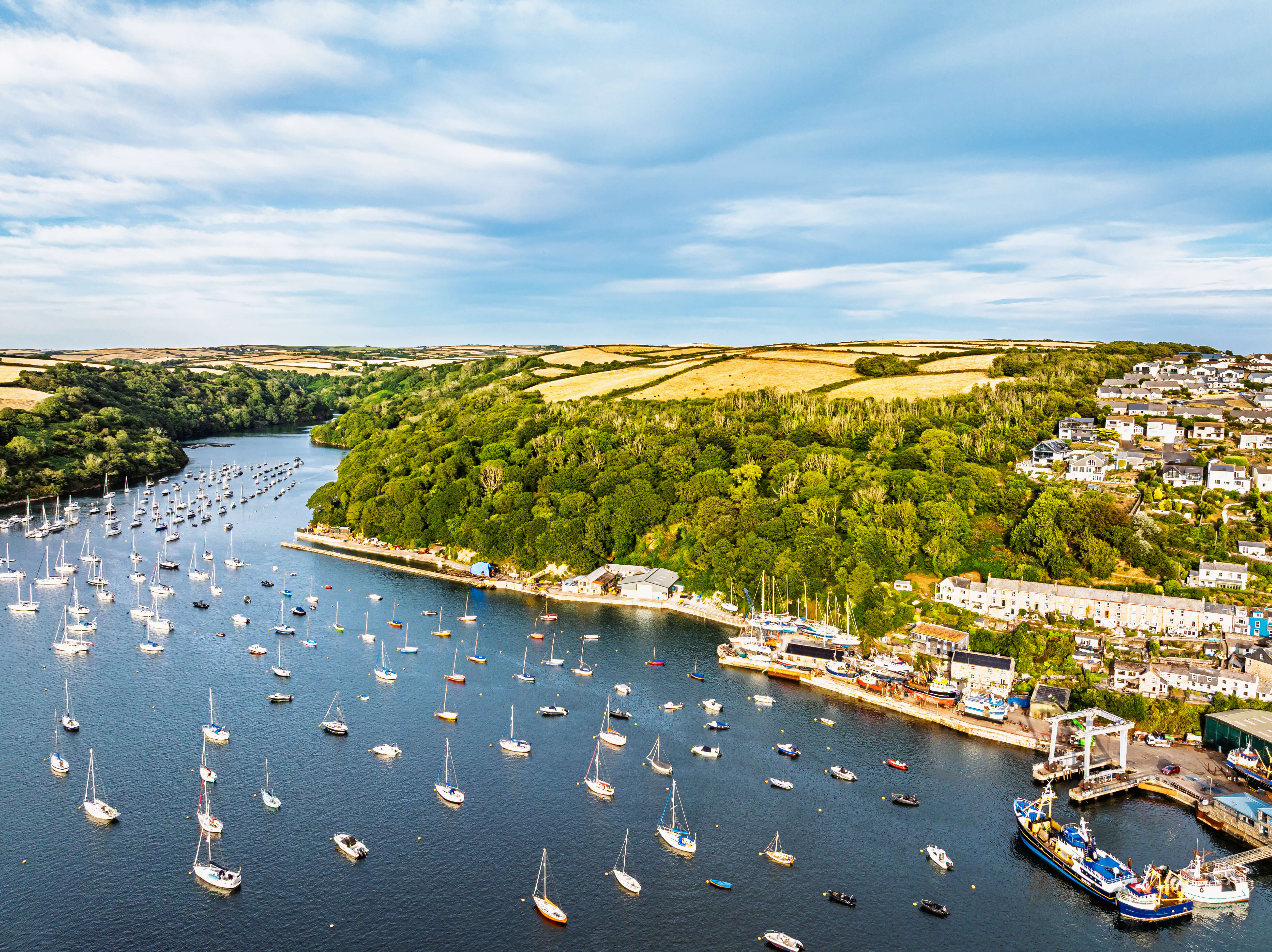 Aerial view of a Cornish harbour and estuary with moored sailing boats