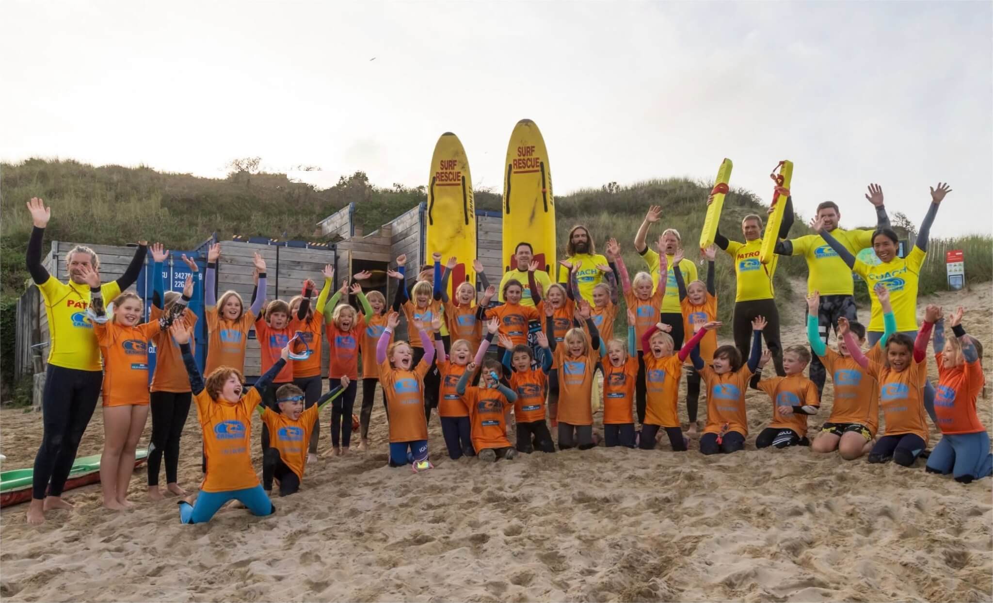 Crantock Surf Life Saving Club coaches and young members cheering on Crantock Beach