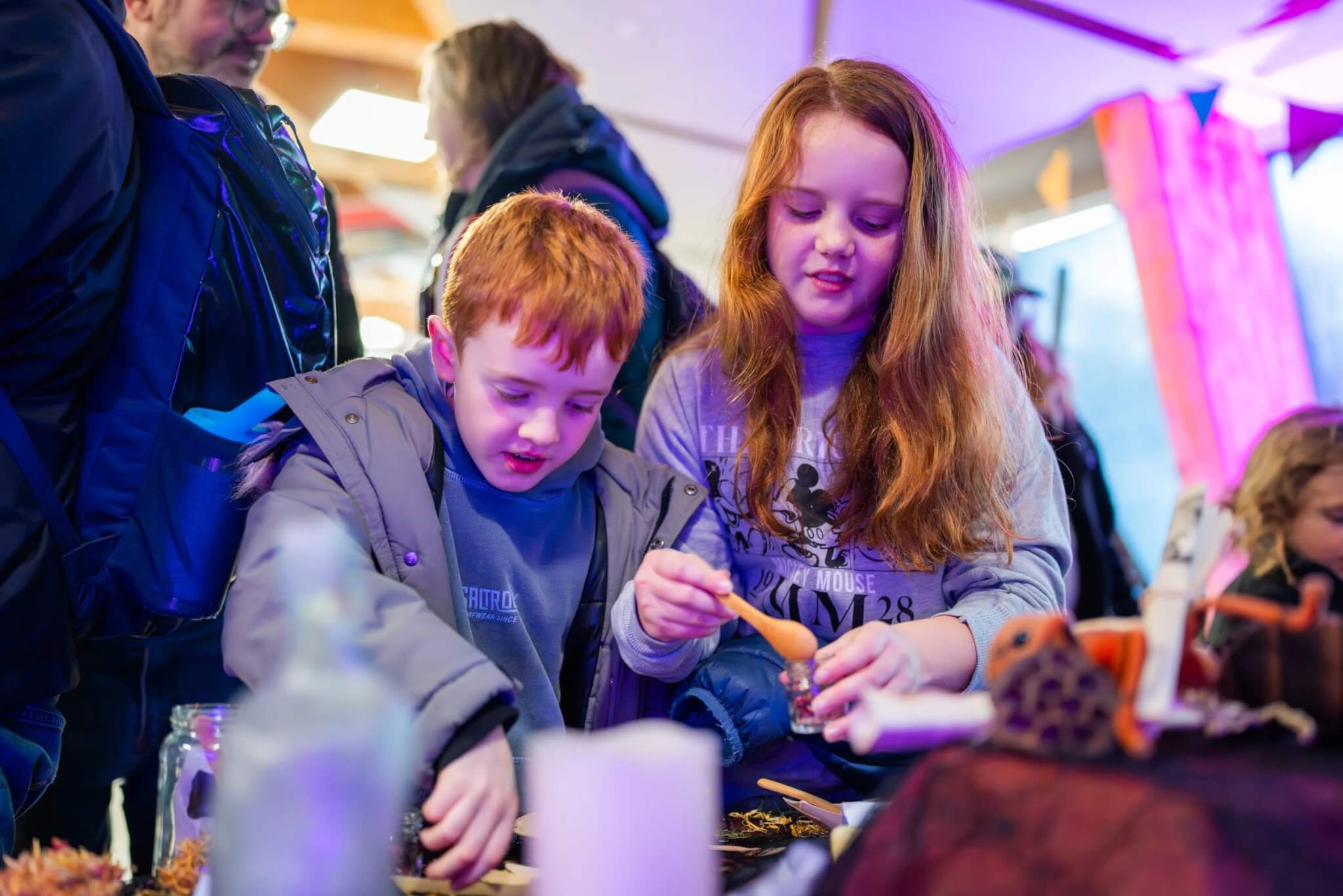 Children painting under UV light in the Hidden Glow Room