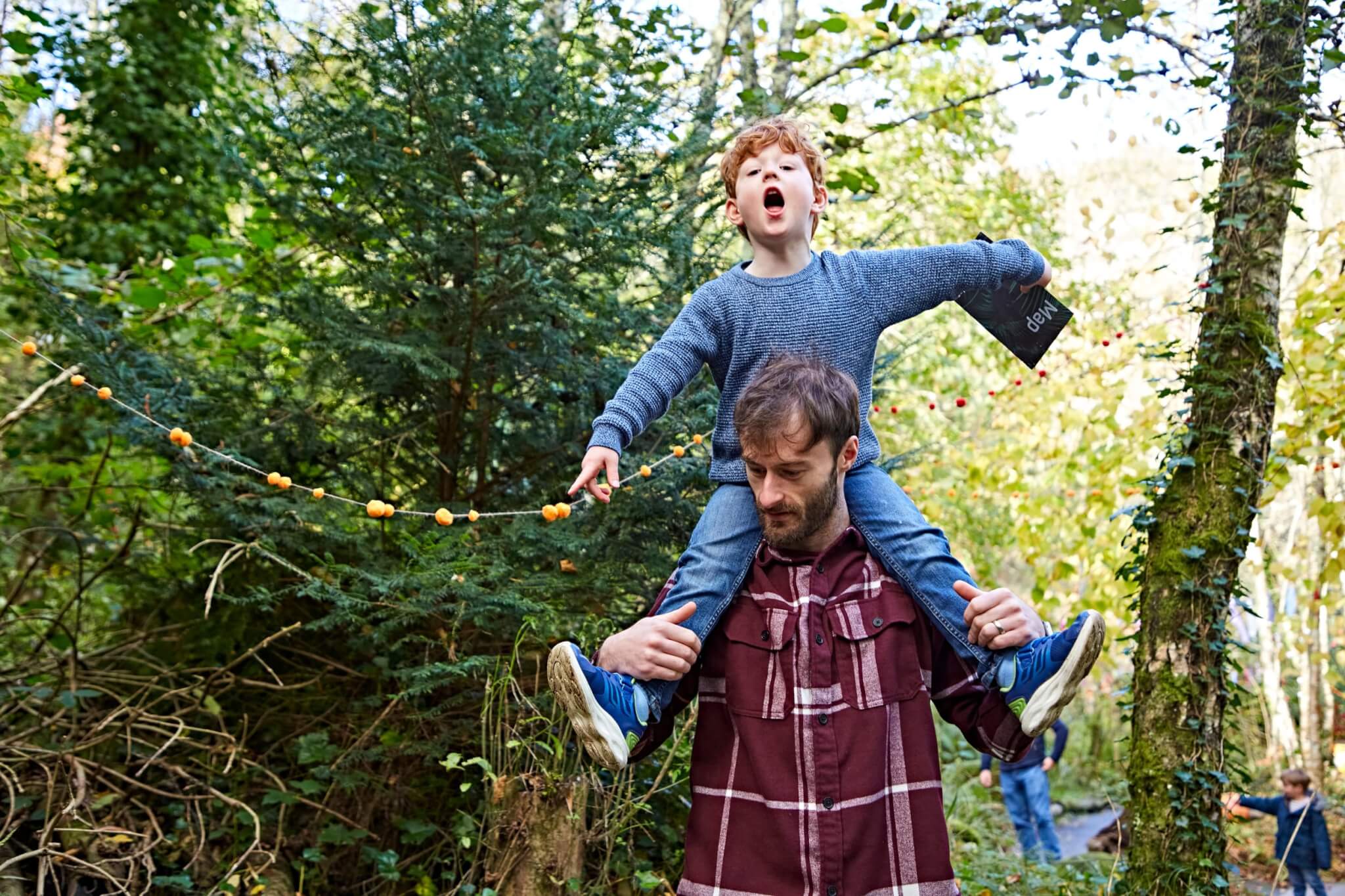Boy on his father's shoulders on the Halloweden trail