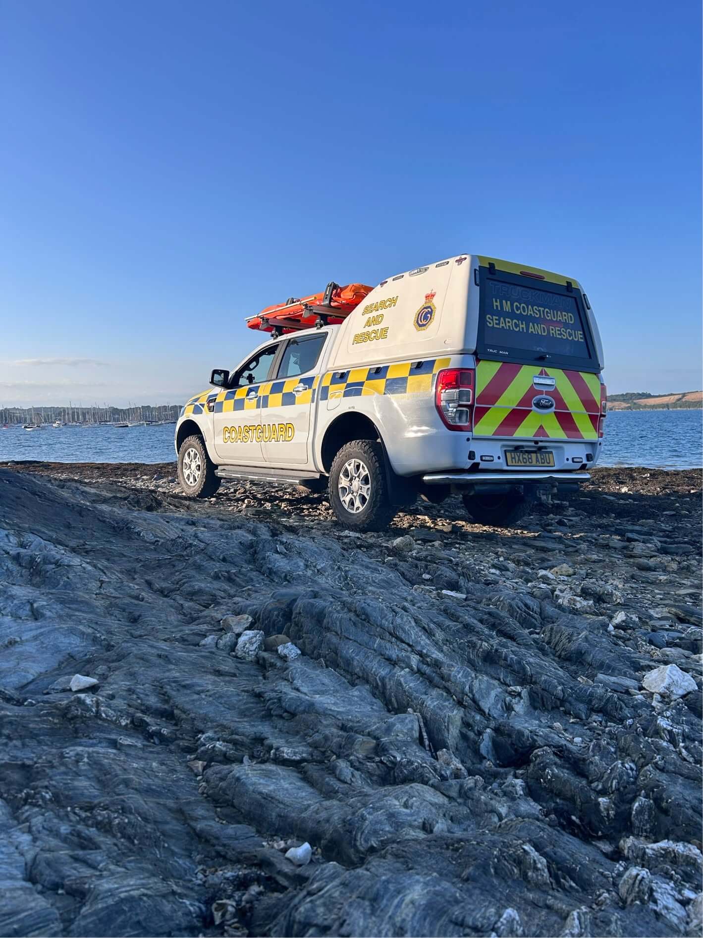 HM Coastguard search and rescue 4x4 parked on rocks overlooking Falmouth Bay