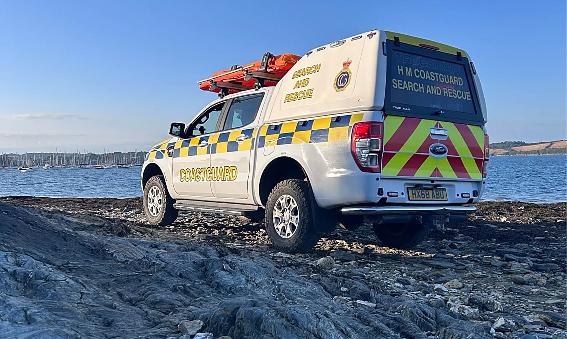 HM Coastguard search and rescue 4x4 parked on rocks overlooking Falmouth Bay