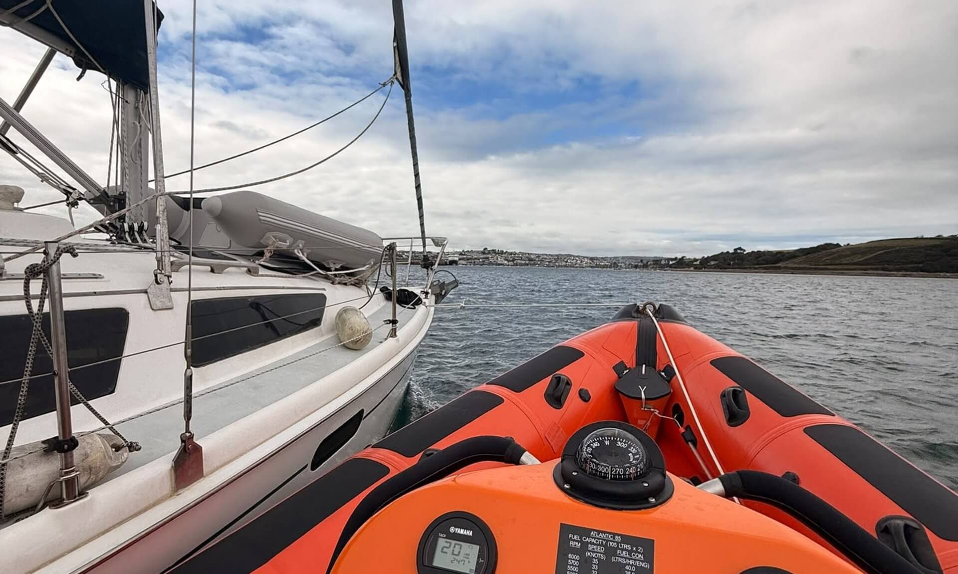 RNLI inshore lifeboat approaching a stricken yacht near Falmouth