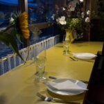 A table set for dinner at Favorita in Newlyn, with sunflowers on the counter
