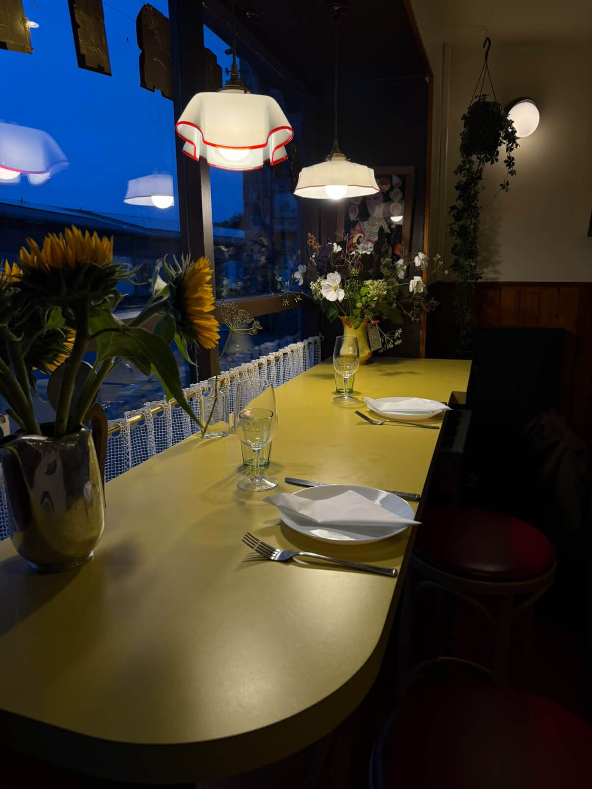 A table set for dinner at Favorita in Newlyn, with sunflowers on the counter