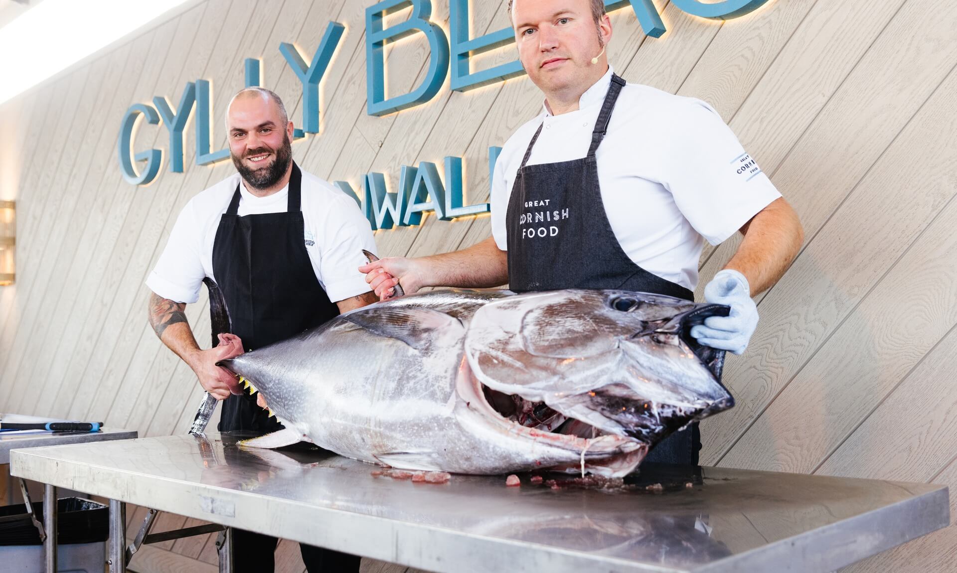 Two chefs with a whole Cornish tuna at Gylly Beach in Falmouth