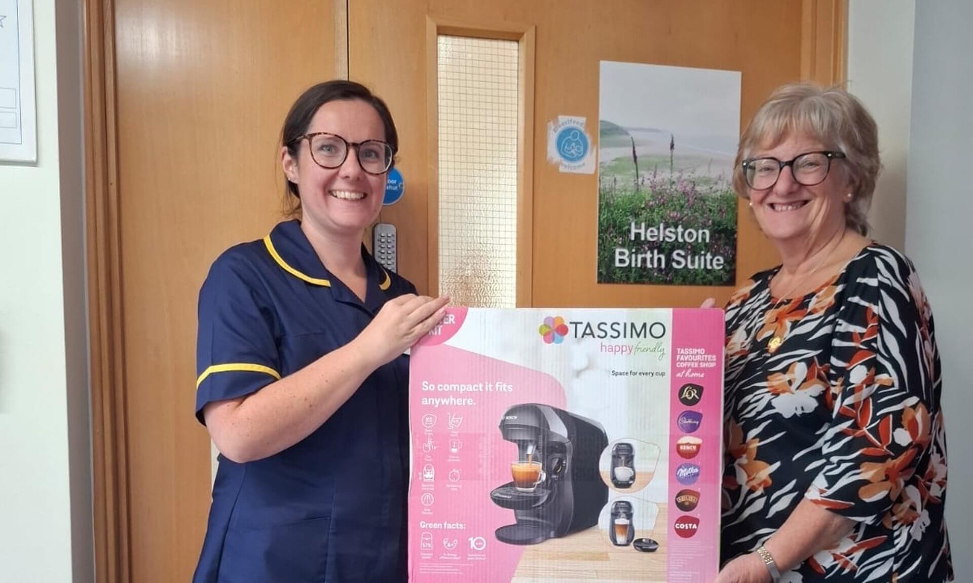 Janice and Fiona holding a boxed coffee machine outside Helston Birth Suite