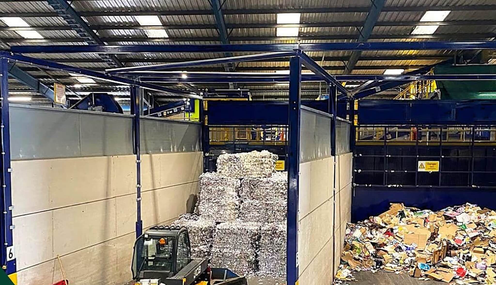 Forklift loader moving baled paper at a Cornwall recycling facility