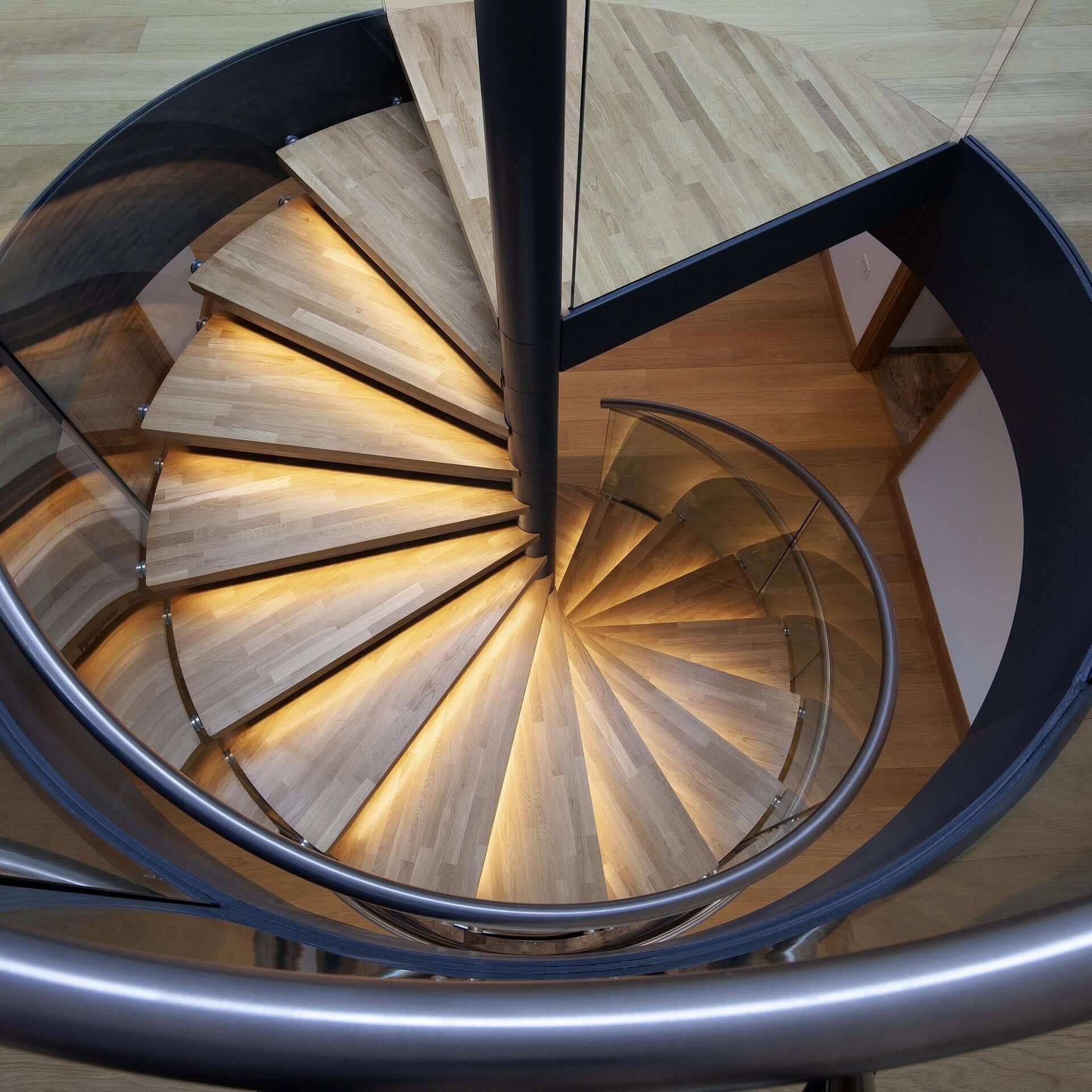 Overhead view of a bespoke spiral staircase with illuminated oak treads