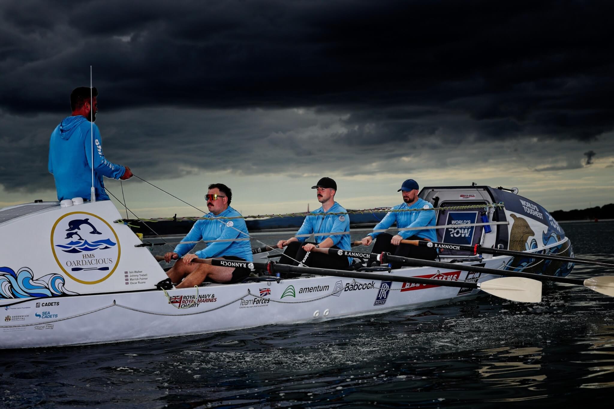 The HMS Oardacious crew rowing under storm clouds