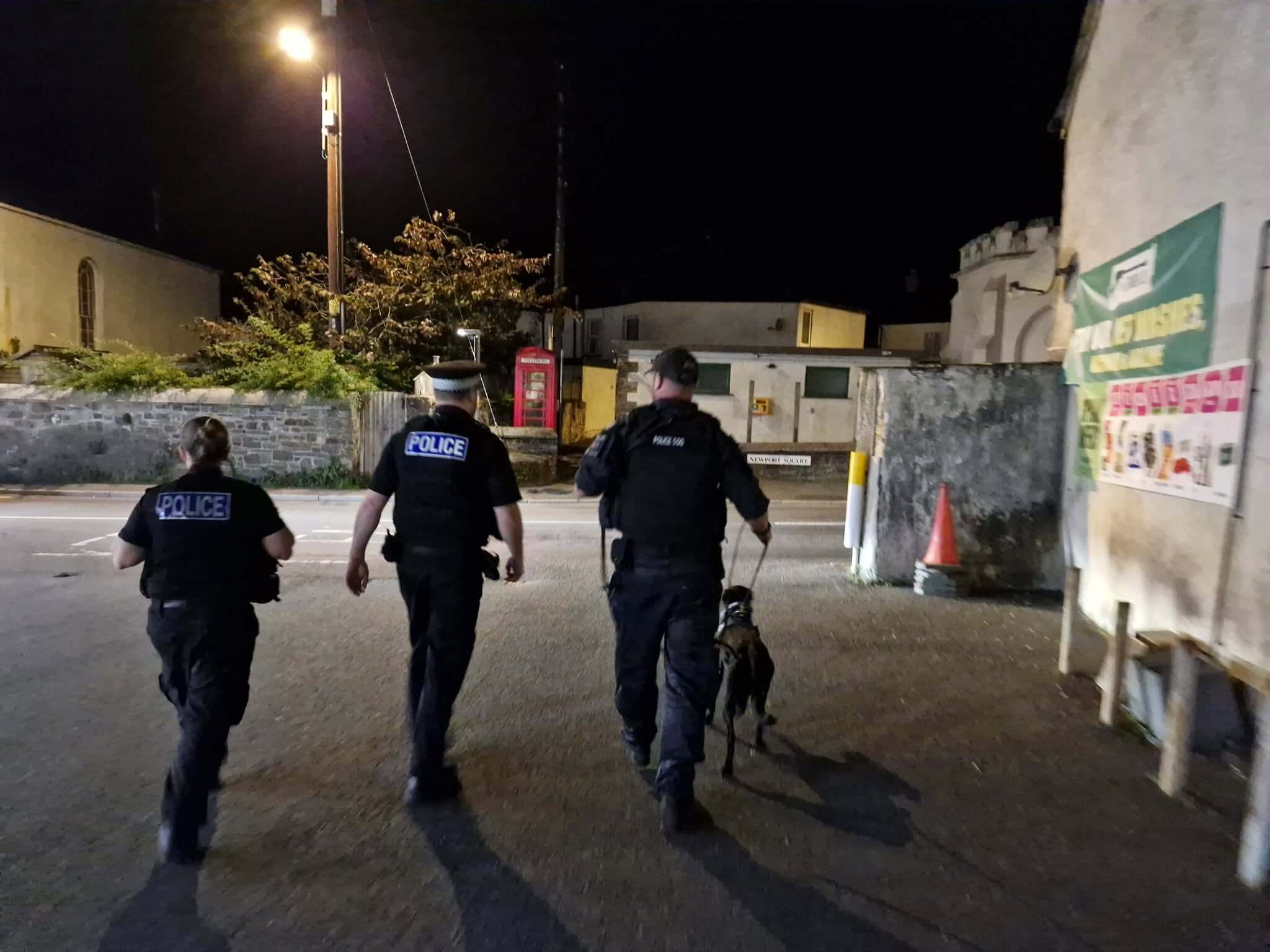 Officers walking with Jasper on an evening patrol