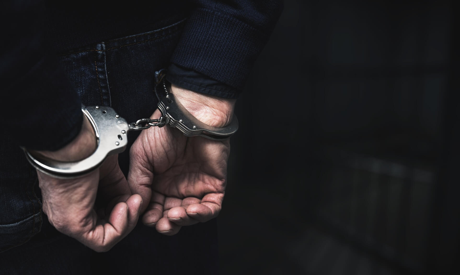 Man in handcuffs with hands behind his back