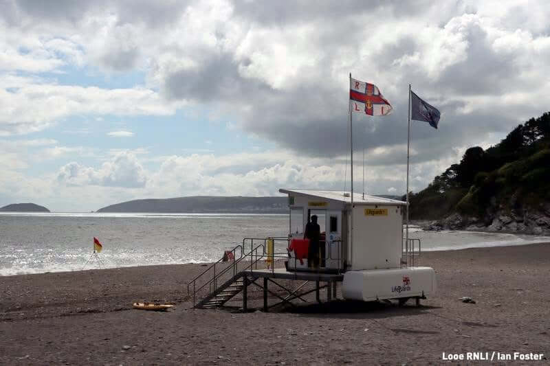 RNLI lifeguard unit with flags flying on a south east Cornwall beach