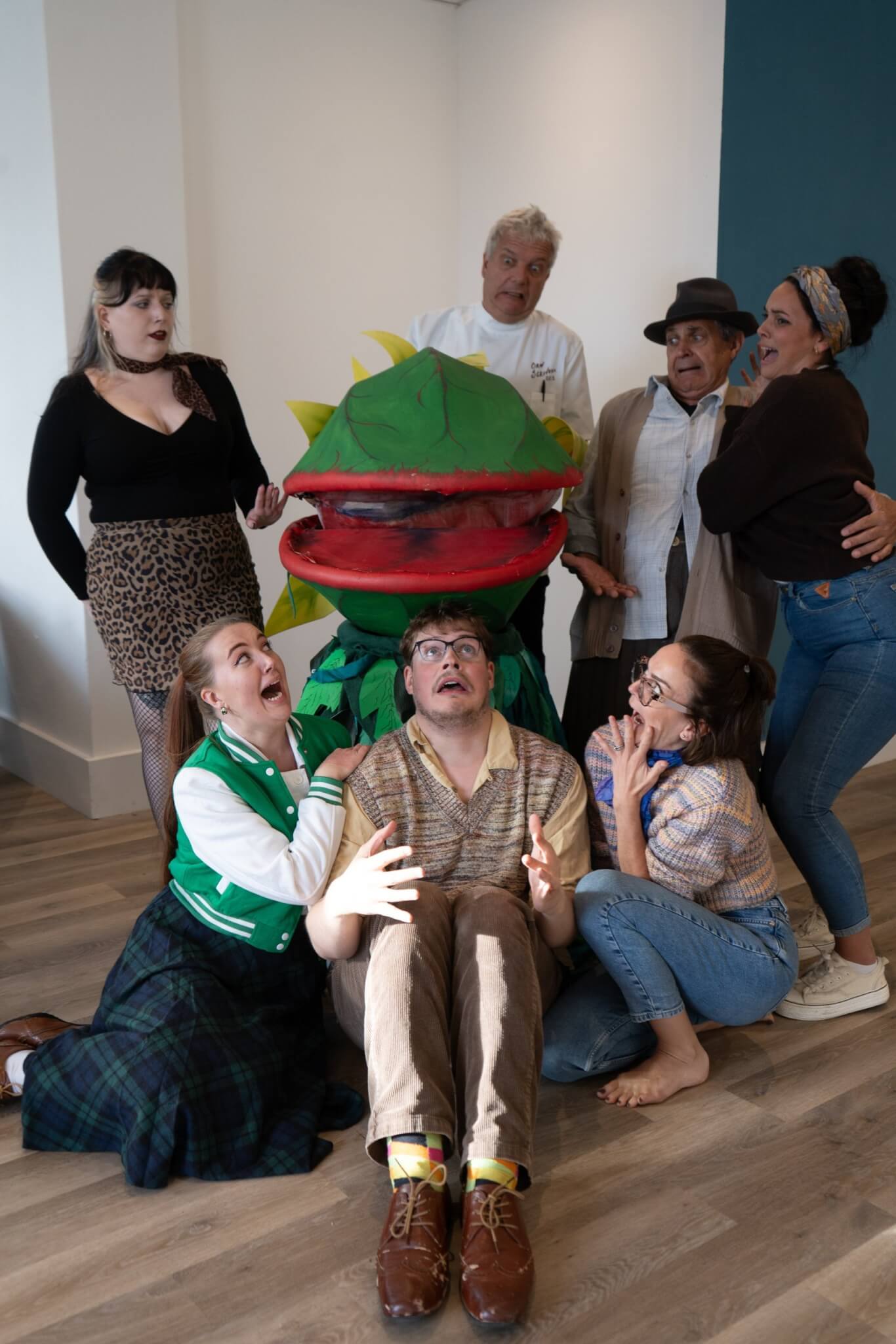Teylu Theatre Company cast recoiling in mock horror around the Audrey II plant puppet
