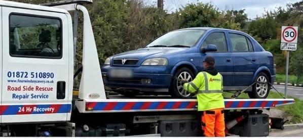 Blue Vauxhall saloon loaded onto a recovery lorry after being seized as untaxed