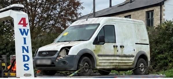 White van with expired tax loaded onto a recovery lorry