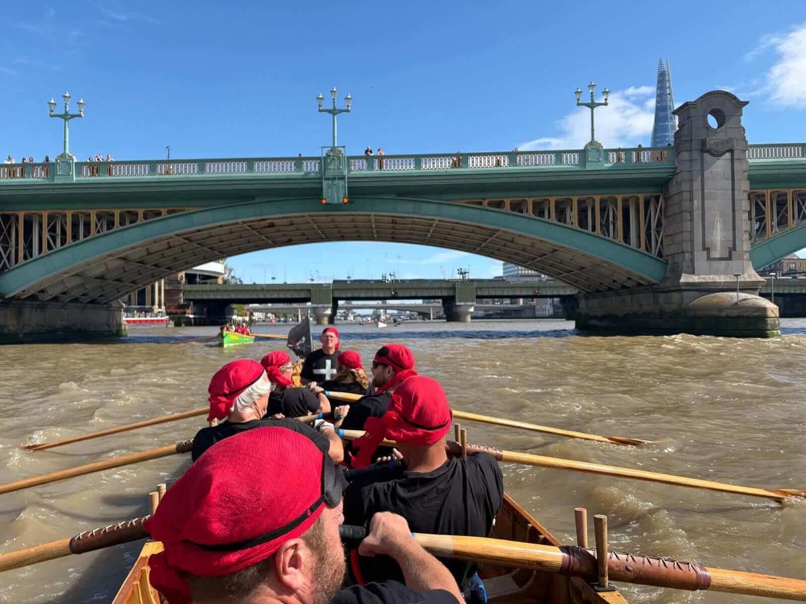 Mevagissey crew rowing under a Thames bridge with the Shard behind