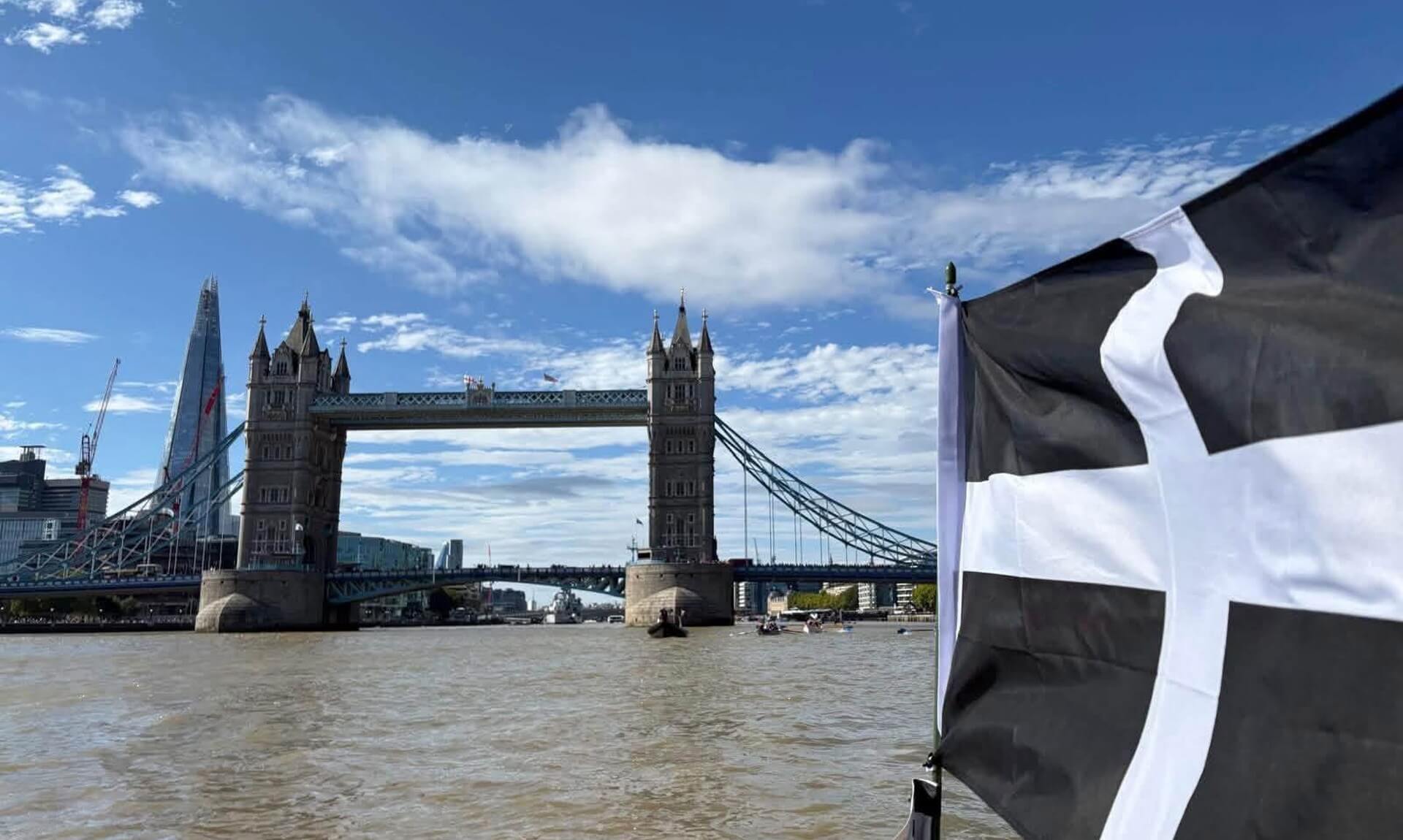 Tower Bridge seen from the Thames with a Cornish flag flying in the foreground