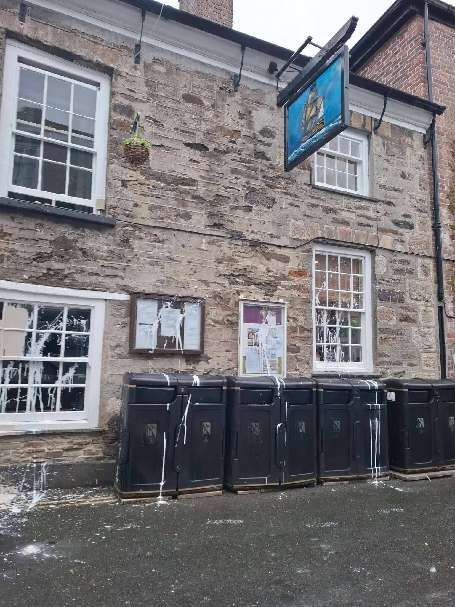 Paint splattered across windows, noticeboards and bins on a Mevagissey street