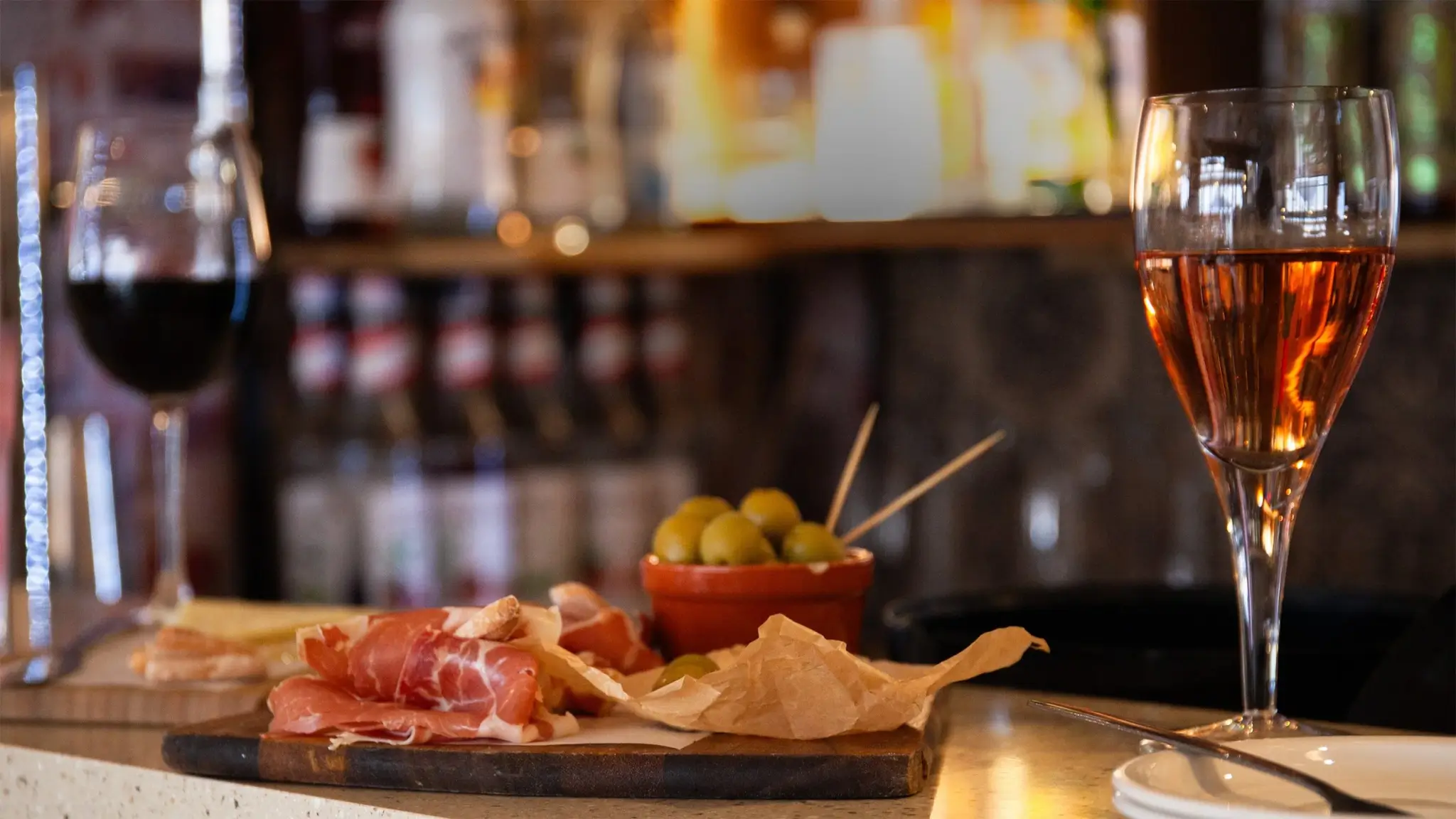 Charcuterie board and wine glasses on the bar at Graze Tapas and Wine, Newquay
