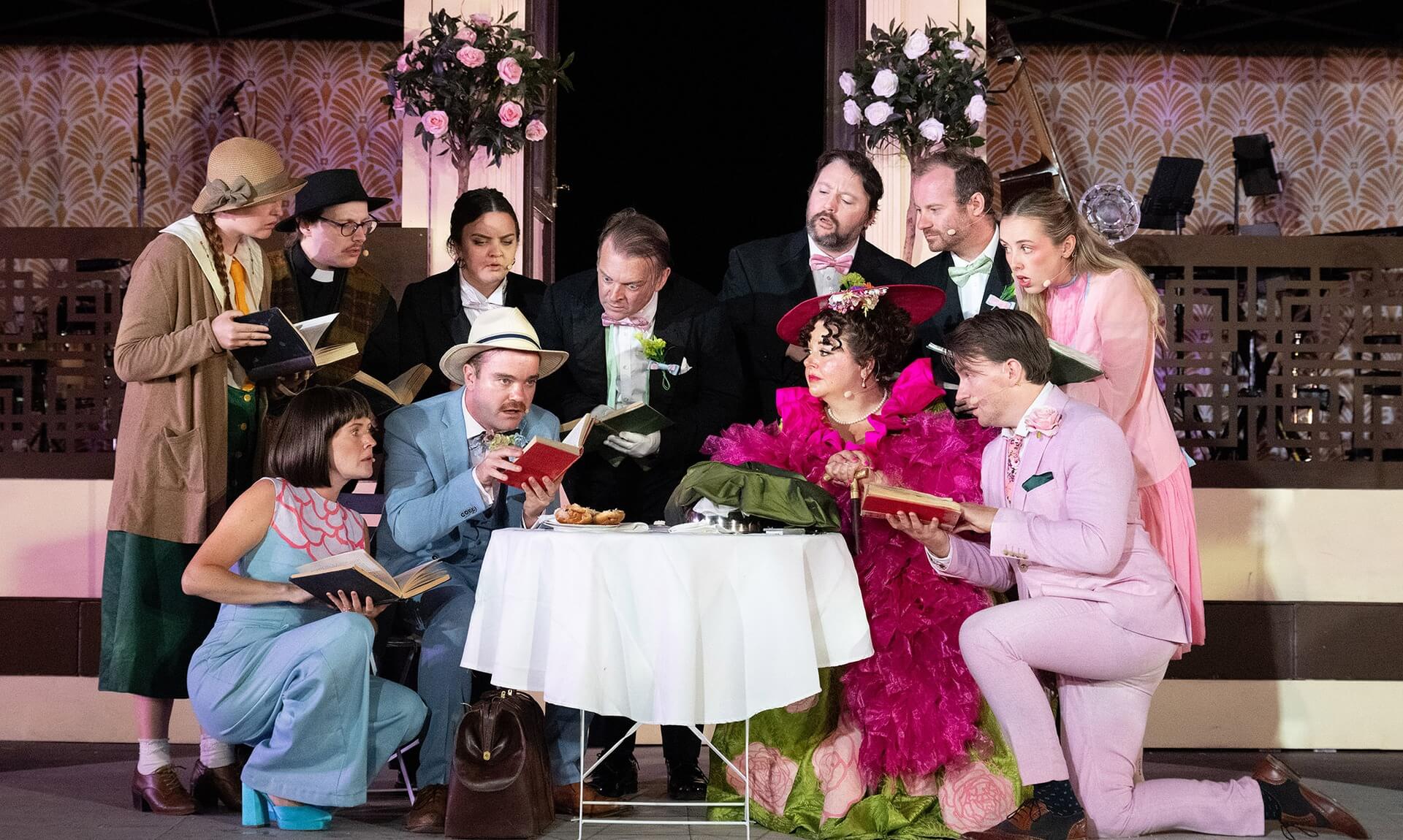 Full cast of OVO's 1920s Importance of Being Earnest around a table at the Minack Theatre