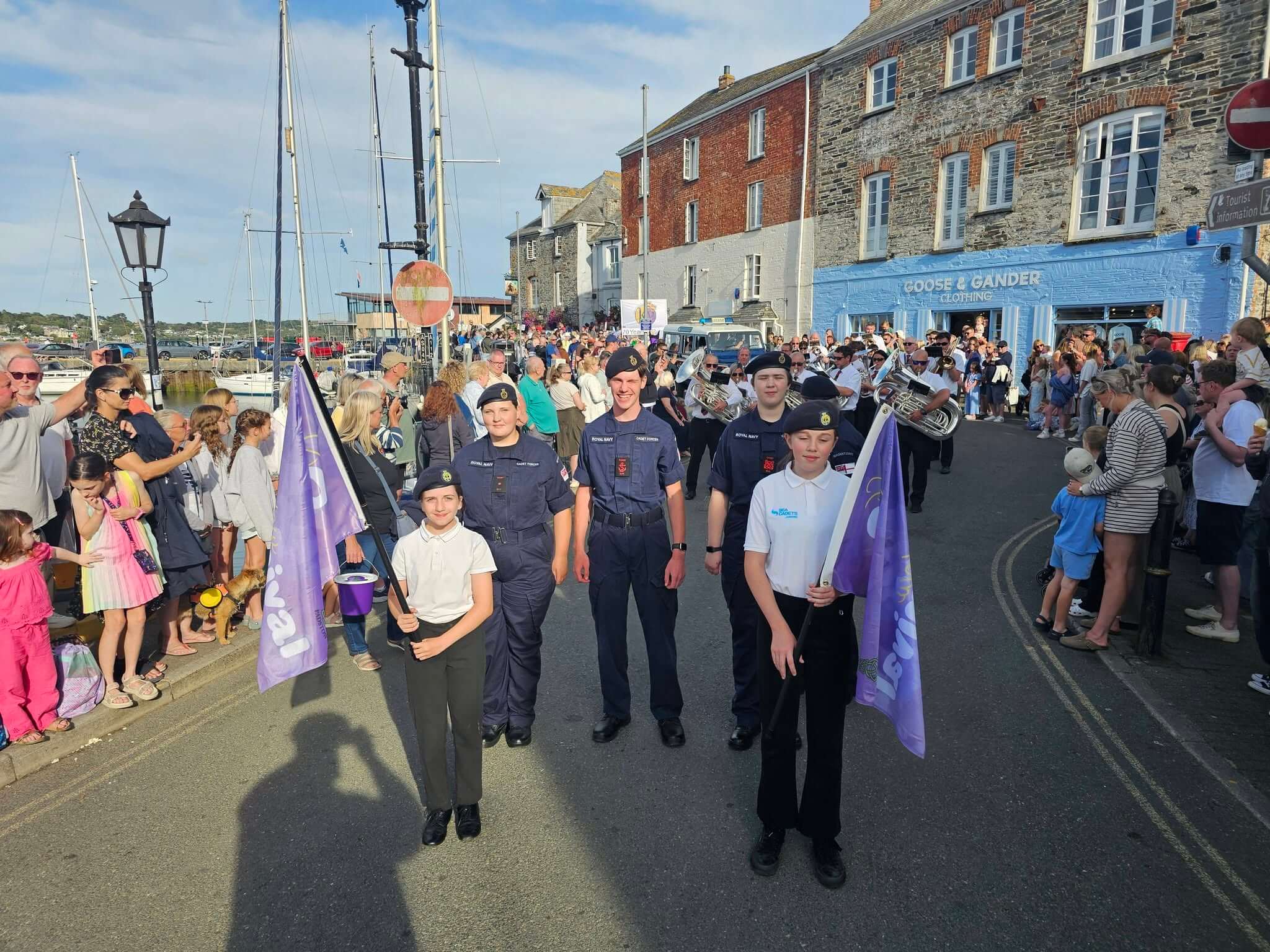 Padstow Sea Cadets marching through the town with a brass band during a summer parade