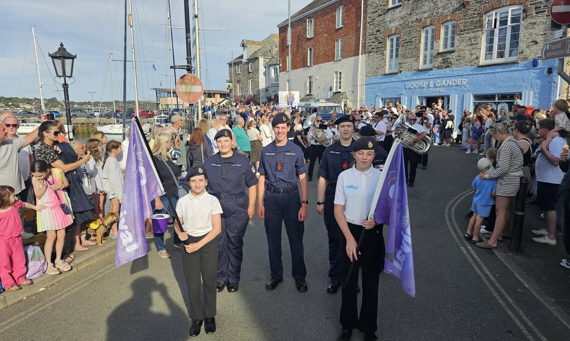 Padstow Sea Cadets marching through the town with a brass band during a summer parade