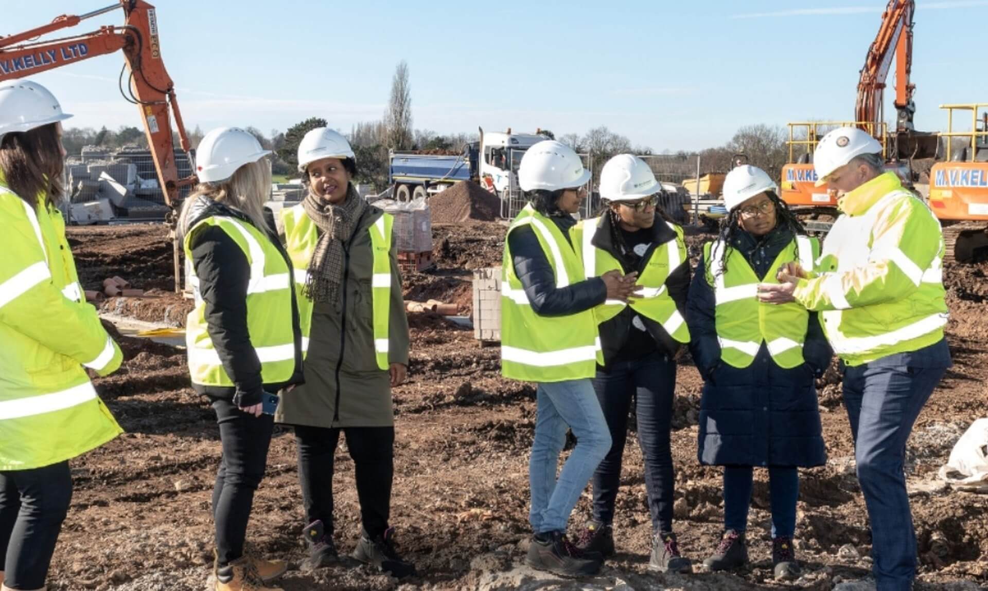 Women in hi-vis and hard hats on a Women into Home Building site visit