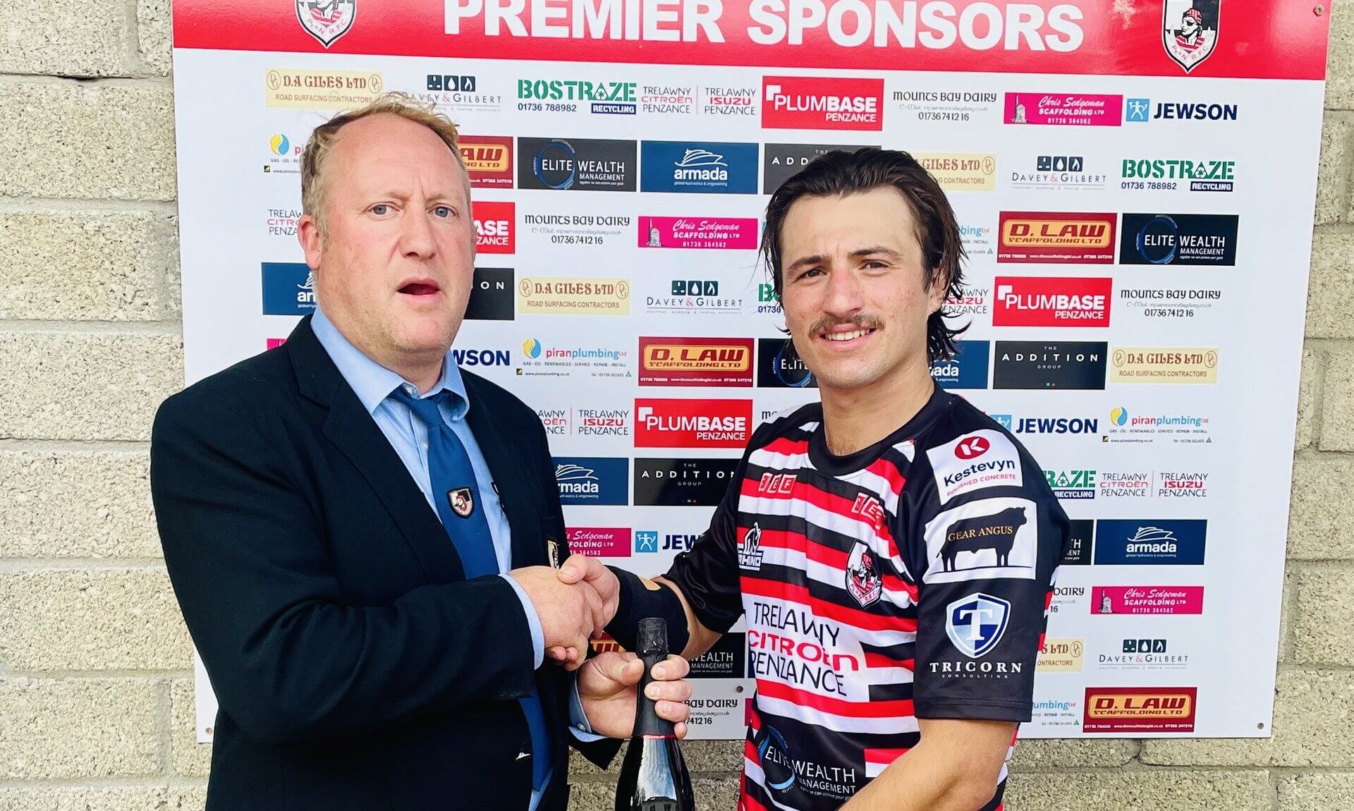Dan Rhys Evans receiving his man of the match award from Jack Nicholas at the Mennaye Field