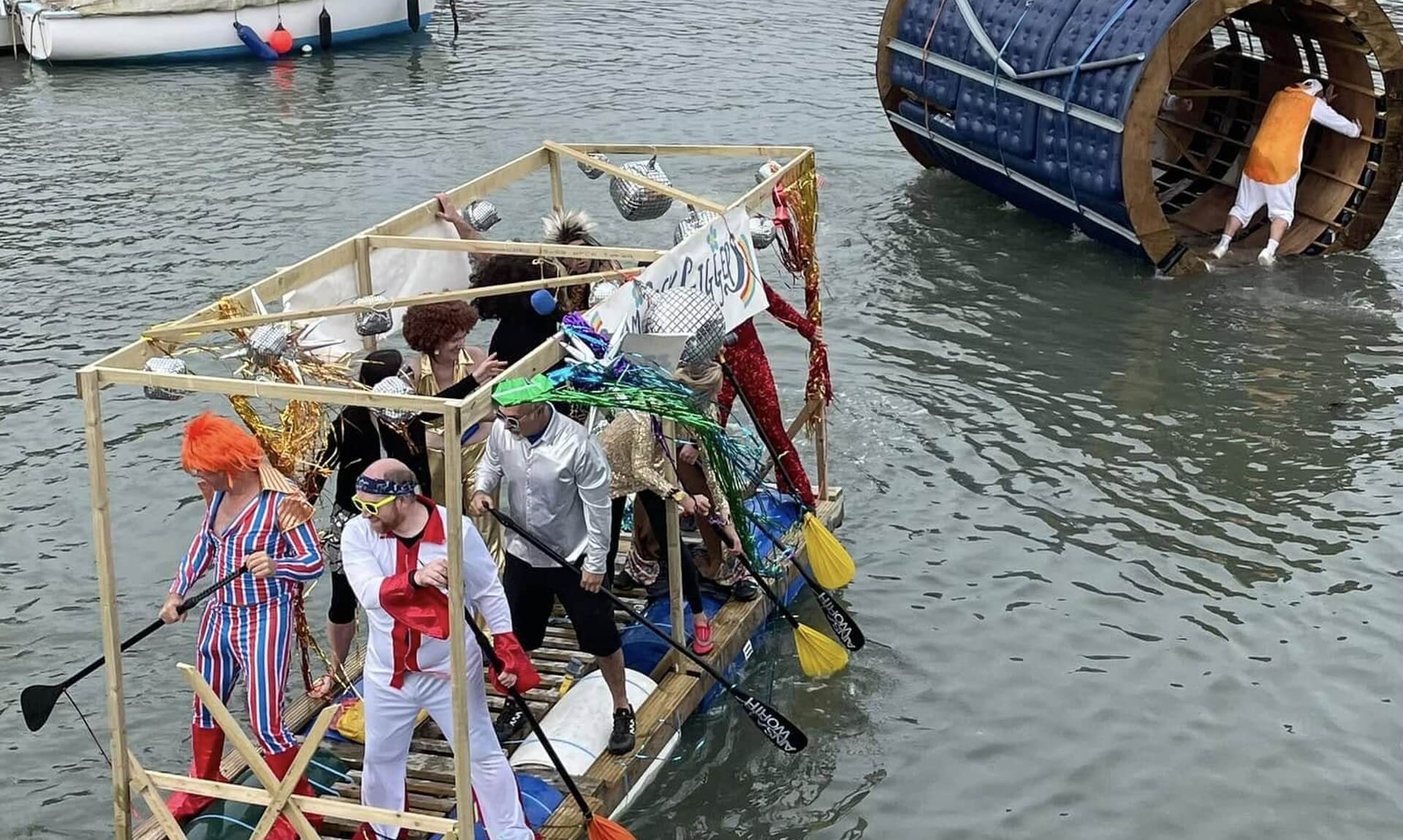 Fancy-dress crews racing home-built rafts across Porthleven Harbour