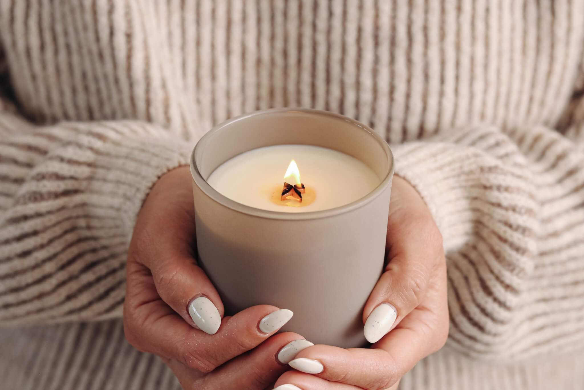 Hands holding a lit candle in remembrance