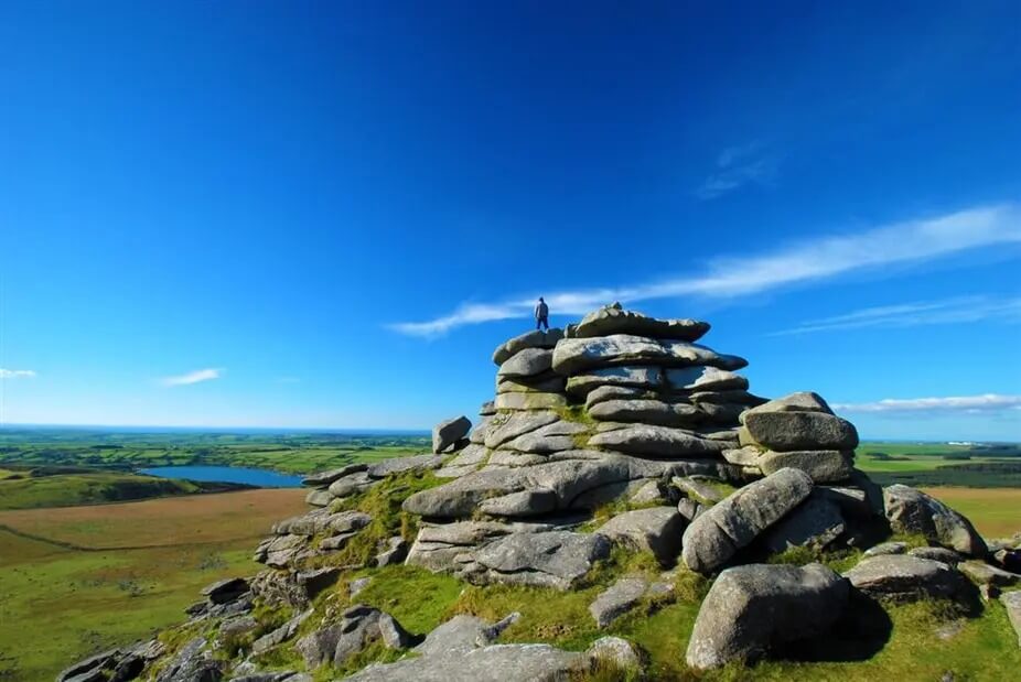 Walker standing on the summit rocks of Rough Tor, Bodmin Moor