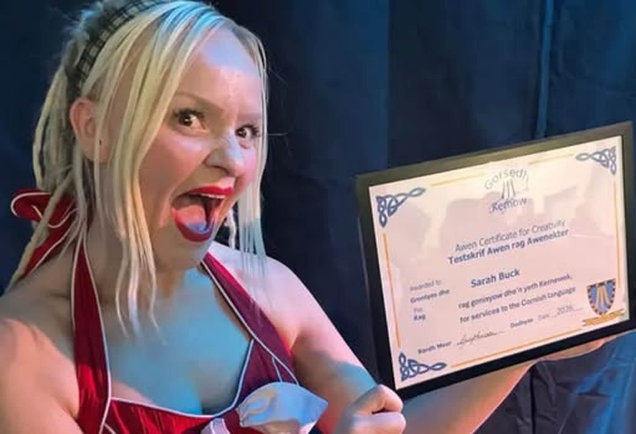 Sarah Buck holding her AWEN Certificate for Creativity from Gorsedh Kernow