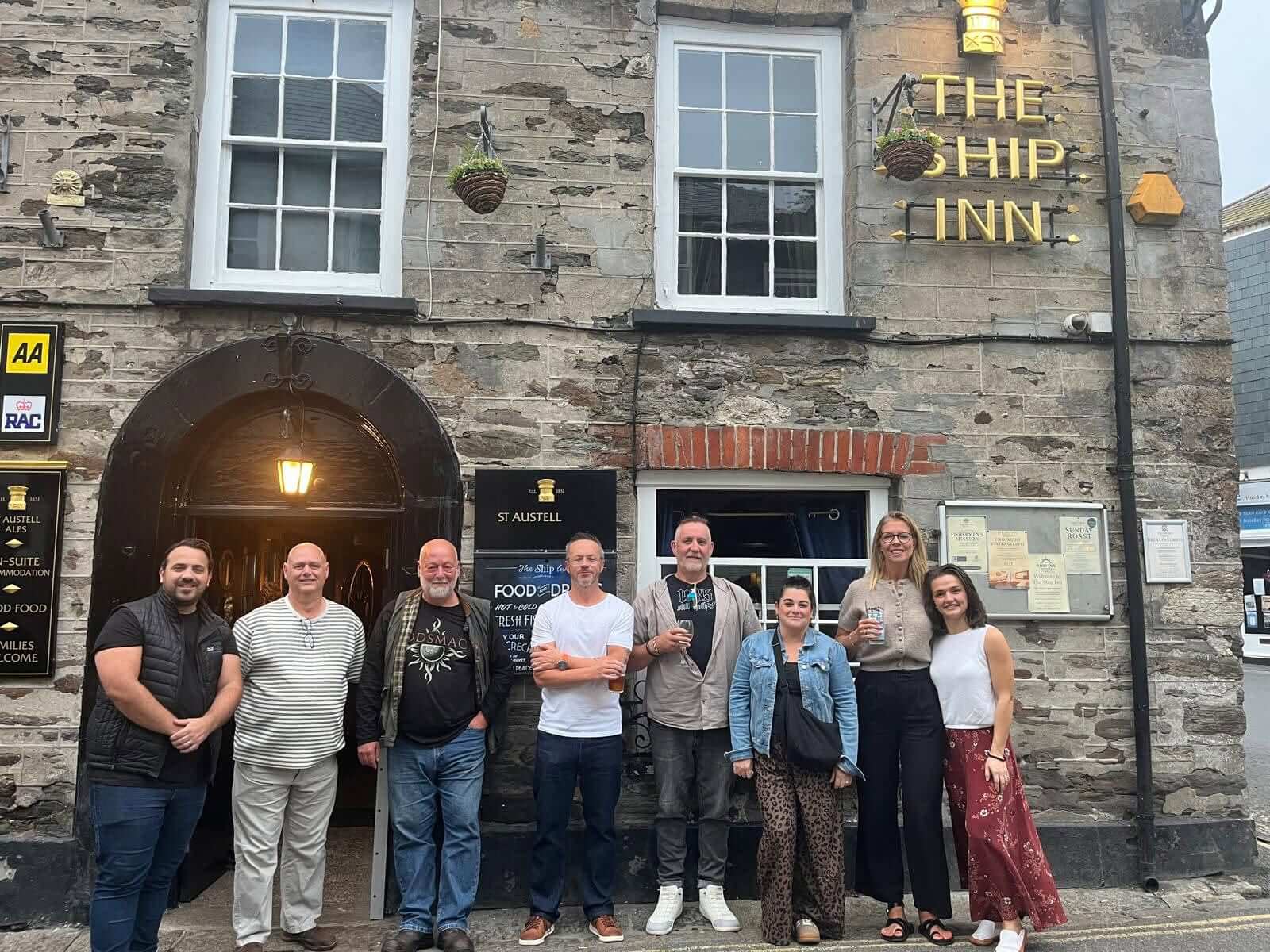 Group of villagers outside The Ship Inn in Mevagissey after helping clean up vandalism