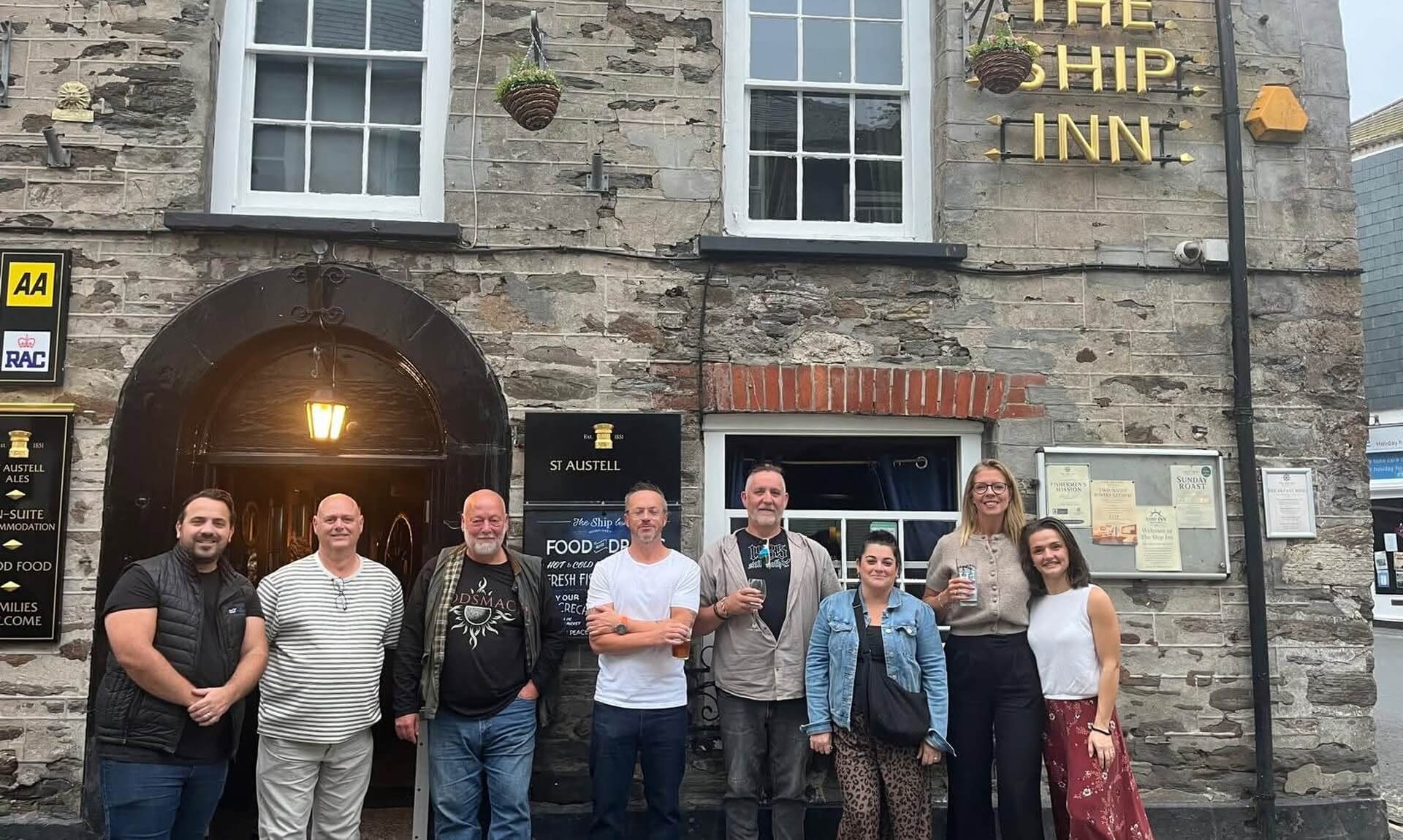 Group of villagers outside The Ship Inn in Mevagissey after helping clean up vandalism