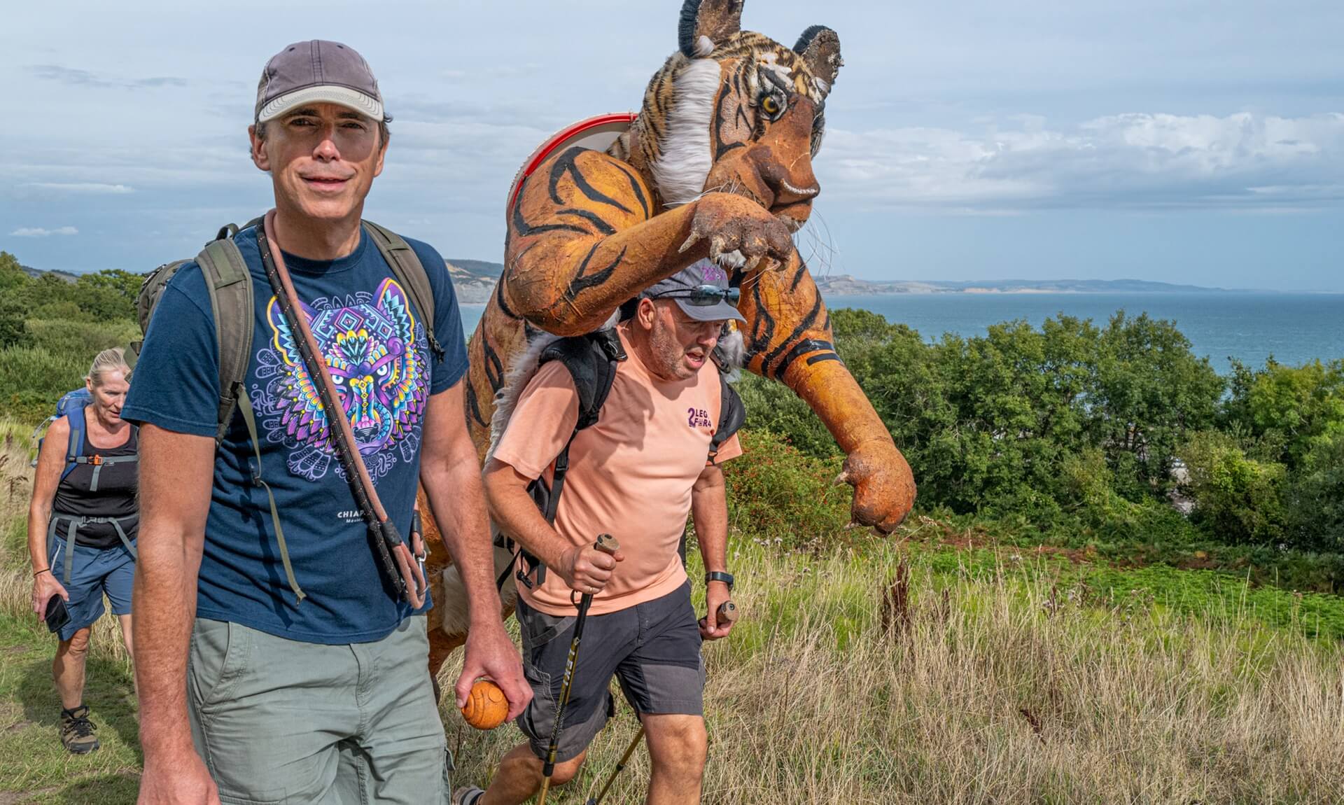 Simon Reeve and Paul Goldstein walking a coastal path with the tiger costume