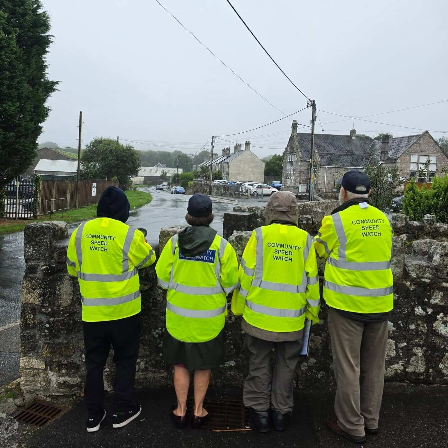 Community Speed Watch volunteers in hi-vis jackets watching traffic from a bridge in St Stephen in Brannel