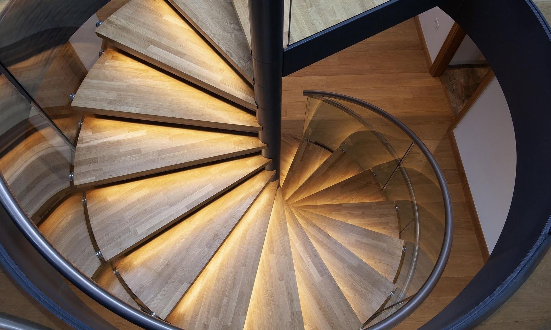 Overhead view of a bespoke spiral staircase with illuminated oak treads