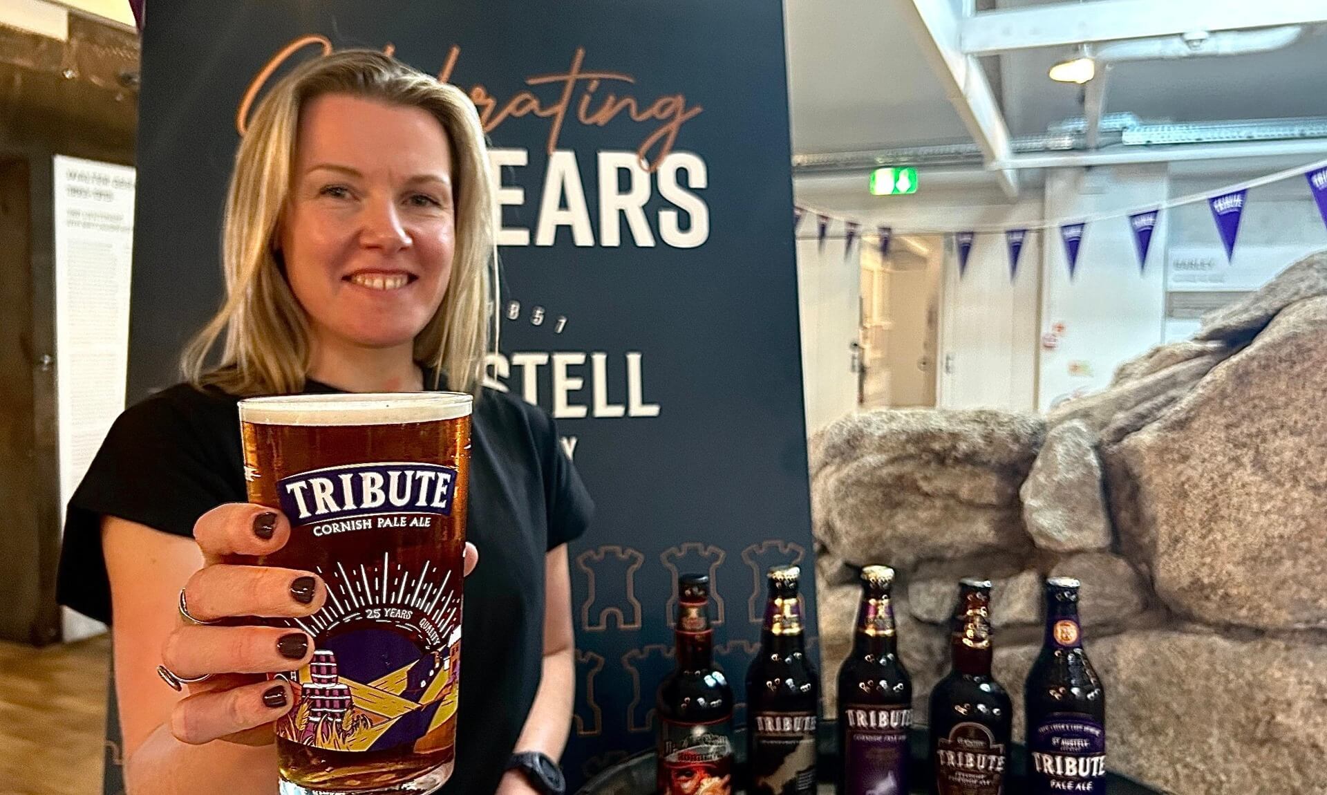 Jo Geeves holding a pint in the new commemorative Tribute glass at St Austell Brewery