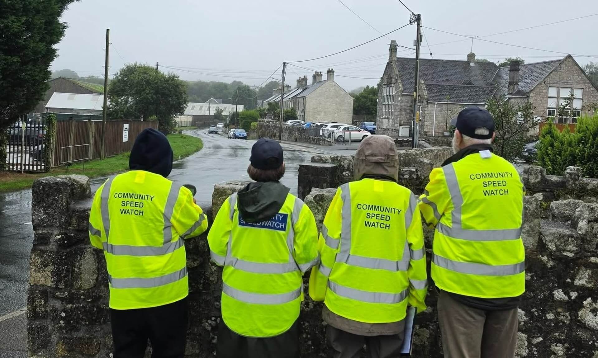 Community Speed Watch volunteers in hi-vis jackets watching traffic from a bridge in St Stephen in Brannel