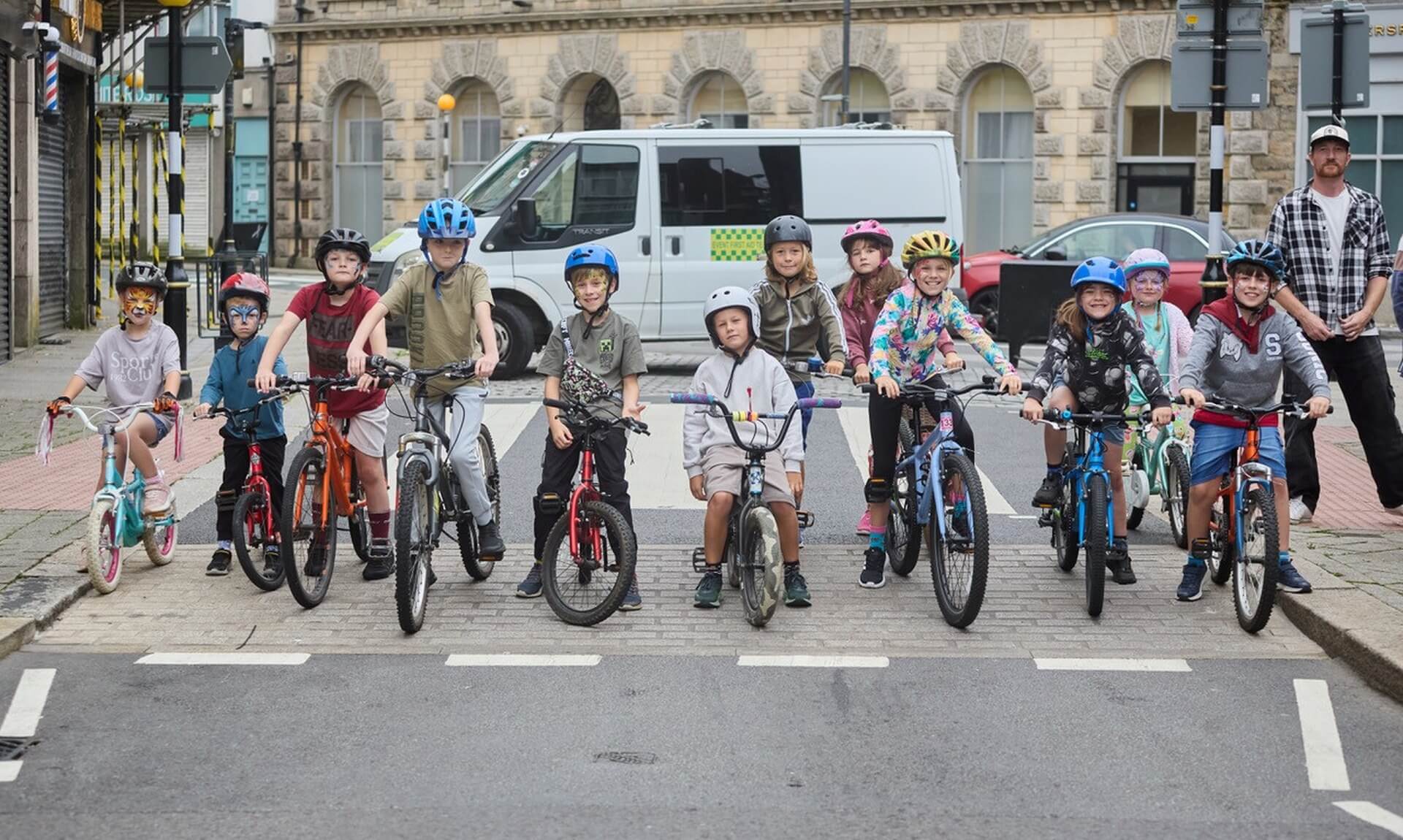 Children lined up on bikes and trikes on Trelowarren Street in Camborne for Tykes on Trikes