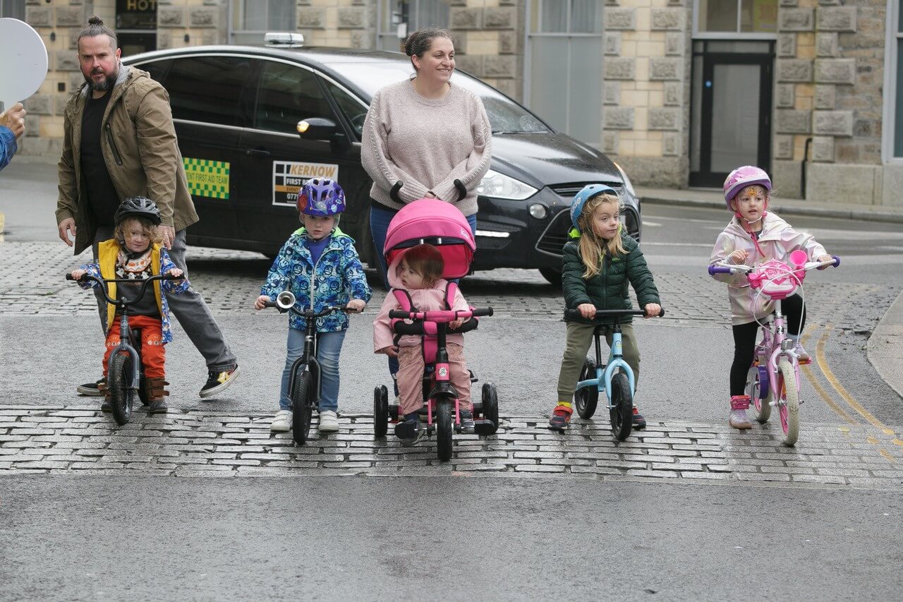Young children on balance bikes and trikes with parents at Tykes on Trikes