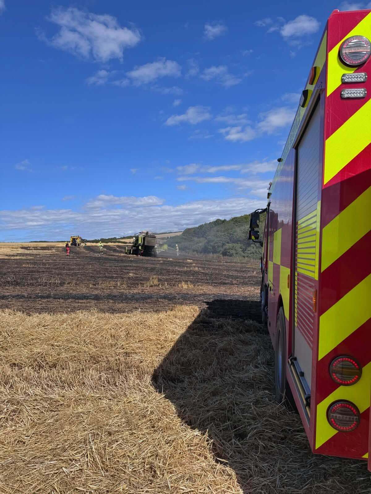 Combine harvester alight in a stubble field