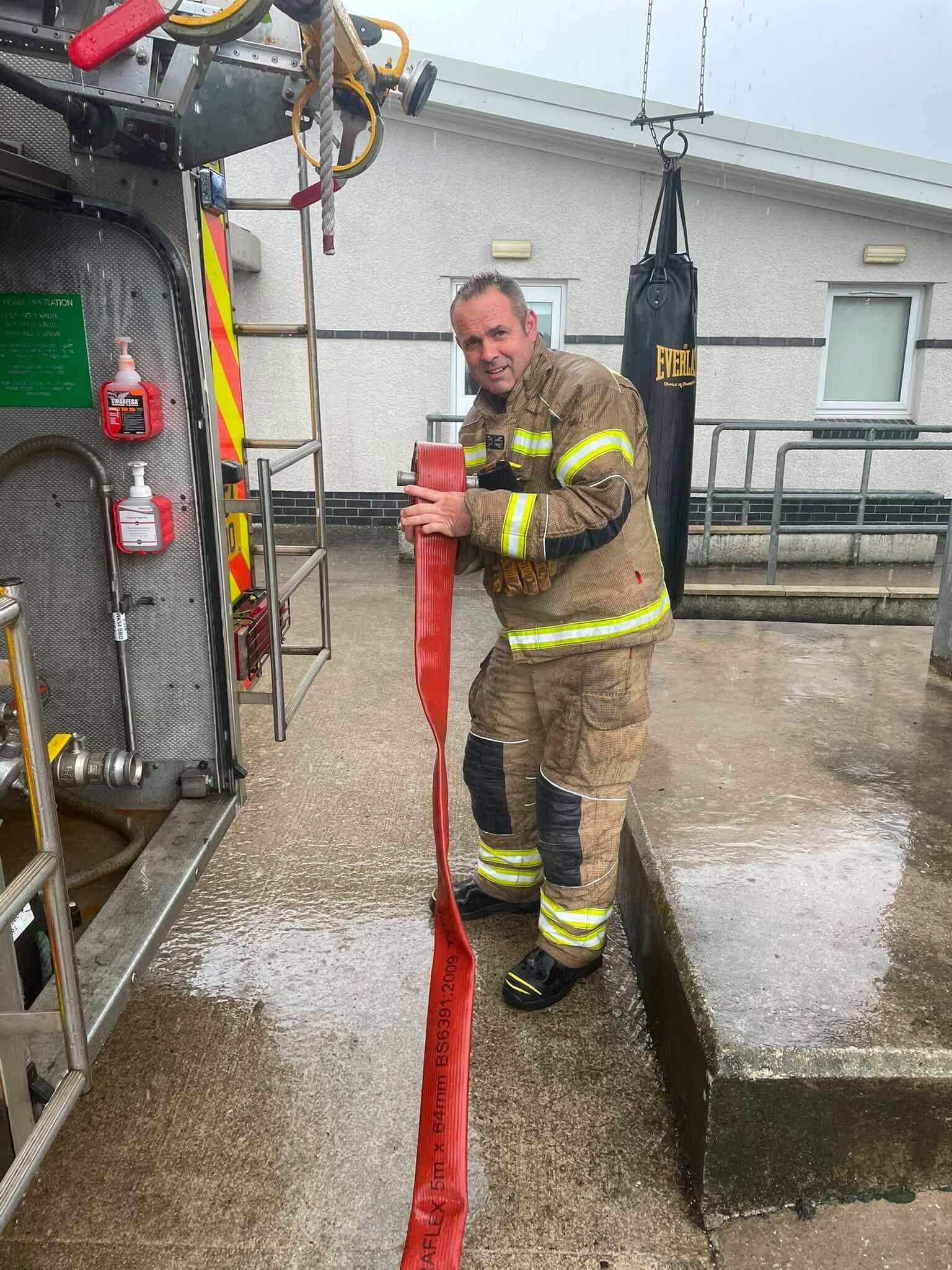 Firefighter cleaning hose at Wadebridge fire station