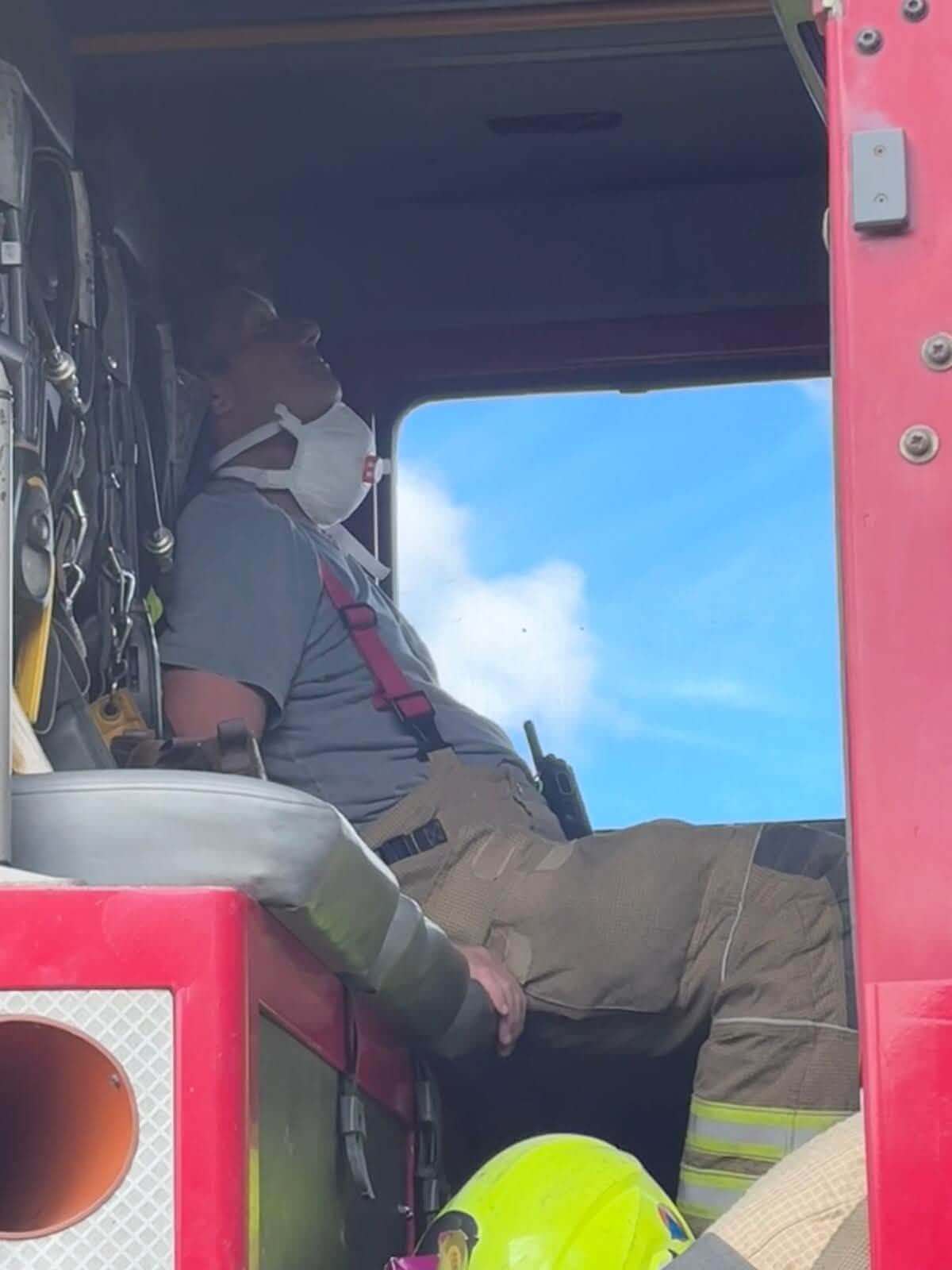 Firefighter resting inside the cab of an appliance